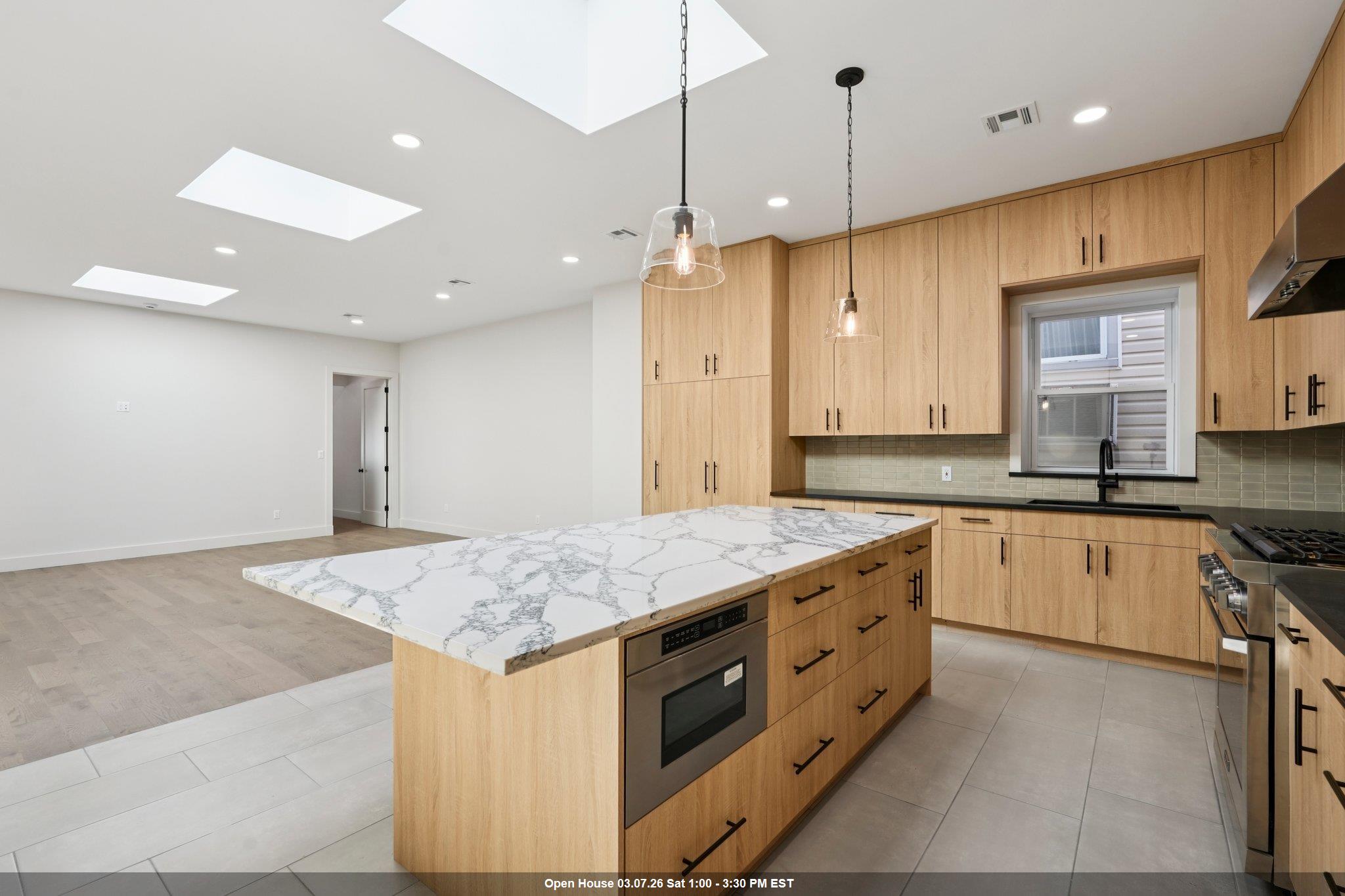 Stunning Warehouse Conversion – Expansive Mother-Daughter Home with Designer Finishes  Welcome to this beautifully converted warehouse, now a breathtaking mother-daughter residence offering approximately 3,400 sq/ft of thoughtfully designed living space. Soaring 10-foot ceilings and 8-foot doors on the main level create a grand and airy ambiance, while oversized windows and three skylights flood the space with natural light.  The heart of the home is the custom chef’s kitchen, featuring a large island with seating for six, sleek Dacor appliances including a 36" gas range, counter-depth refrigerator, and integrated dishwasher—all seamlessly clad in matching cabinetry. The open-concept layout connects the kitchen to an expansive living and dining area, ideal for entertaining. A stylish half bath is conveniently located for guests.  Throughout the home, you'll find 5" wide-plank hardwood and imported Italian tile flooring. The luxurious primary suite includes a walk-in closet and private en-suite bath, while two additional bedrooms share a spacious Jack and Jill bathroom.  Step outside to a fully finished backyard oasis complete with pavers, privacy fencing, and both gas and electric hook-ups—perfect for outdoor gatherings.  The lower level offers a separate living space, ideal for extended family or guests, with its own bedroom, full bath, kitchenette, laundry room, and a massive entertainment area surrounded by custom cabinetry and storage.  Every inch of this home has been meticulously updated—new HVAC, roof, windows, plumbing, electrical, and more. The builder has truly thought of everything. This one-of-a-kind property is a must-see!