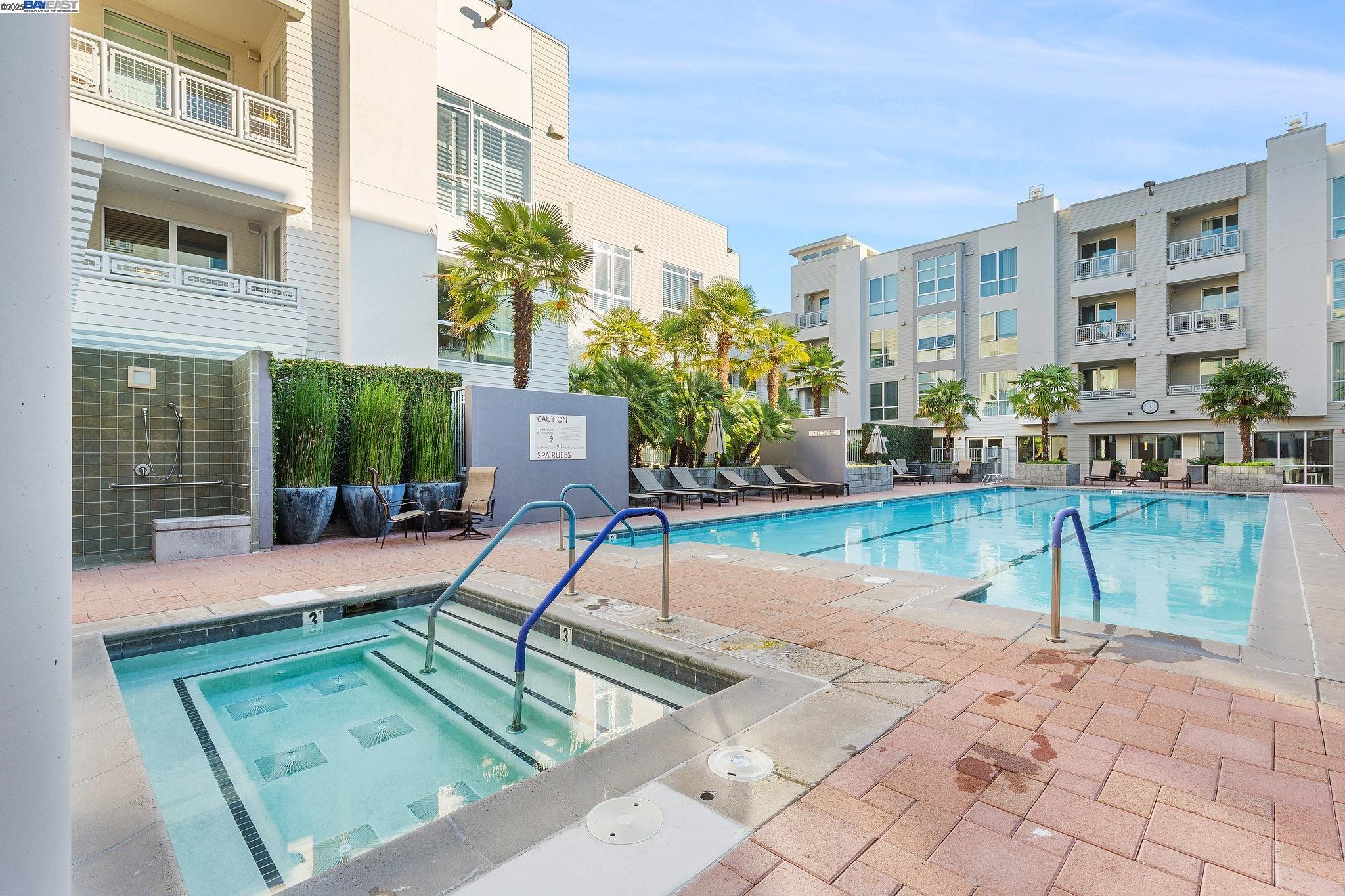 Luxury and convenience meet in this top-floor Mercer condo in the heart of downtown Walnut Creek. With 2 bedrooms and 2 baths across a spacious open layout, this home is filled with natural light through floor-to-ceiling windows and enhanced by higher ceilings exclusive to the 4th floor, modern flooring, and fresh paint. The gourmet kitchen features Sub-Zero and Bosch appliances, stone countertops, and a breakfast bar, flowing seamlessly into the dining and living areas. The primary suite offers a walk-in closet and a spa-inspired bathroom with double vanity, soaking tub, and separate shower. The second bedroom and full bath are ideal for guests, a home office, or both, while the laundry room with side-by-side washer/dryer and cabinetry adds everyday convenience.  Step outside to a covered patio overlooking the courtyard, or enjoy resort-style amenities including a pool, spa, gym, clubhouse, and BBQ area. Two side-by-side parking spaces and a storage unit complete the package. All of this just minutes from BART, freeway access, Broadway Plaza shopping, and Walnut Creek’s top dining and cultural destinations.  Photos were taken when the home was professionally staged and may not reflect the home’s current appearance.
