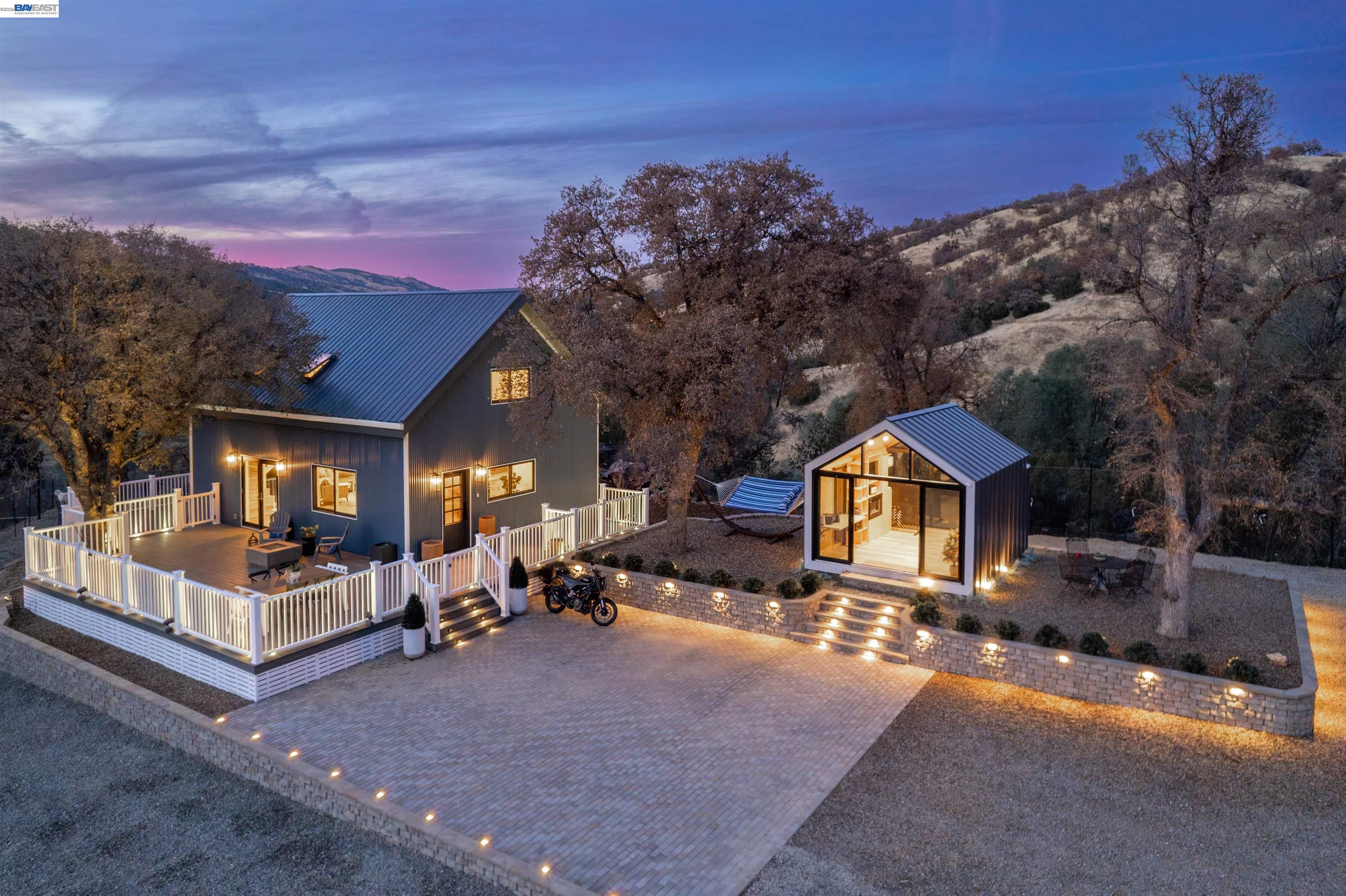 Ready to trade hustle for horizon? Just 35 minutes from downtown Livermore, this is your perfect escape. Set on two parcels totaling nearly 30 acres, including 7.42 acres of open pasture along the Arroyo Mocho Creek, this property is perfectly suited as a turnkey weekend retreat today and a future equestrian estate, compound, or business venture tomorrow. At the end of a private drive sits the 1200 sq ft main home, blending rustic character w/ modern comfort, featuring open-concept living, chef’s kitchen w/ Viking range & stainless appliances, a loft bedroom, & two full bathrooms. A separate Bunkie guest cabin offers flexible space for guests or work-from-home living, complete w/ a high-speed mesh network. Outdoor living takes center stage w/ wraparound Trex deck, SONOS sound system, pizza oven, fire pit, & sweeping 360-degree views, an ideal setting for quiet evenings under the stars. Additional structures include a 1200 sqft shop, a barn ready for horses or animals, and room to roam, ride, or build something bigger. Every system has been thoughtfully designed & automated: owned solar w/ batteries, two commercial generators, two propane tanks, heat pump, A/C, whole-home water filtration, well and 14,000 gallons of water storage—making off-grid living effortless.