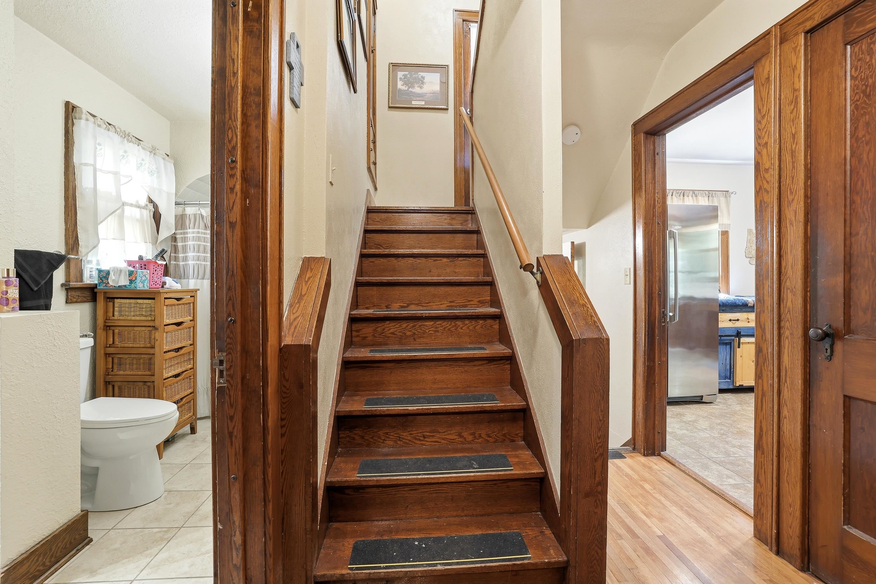 View to bathroom on the left. Stairs in the middle. Pantry door to the right.