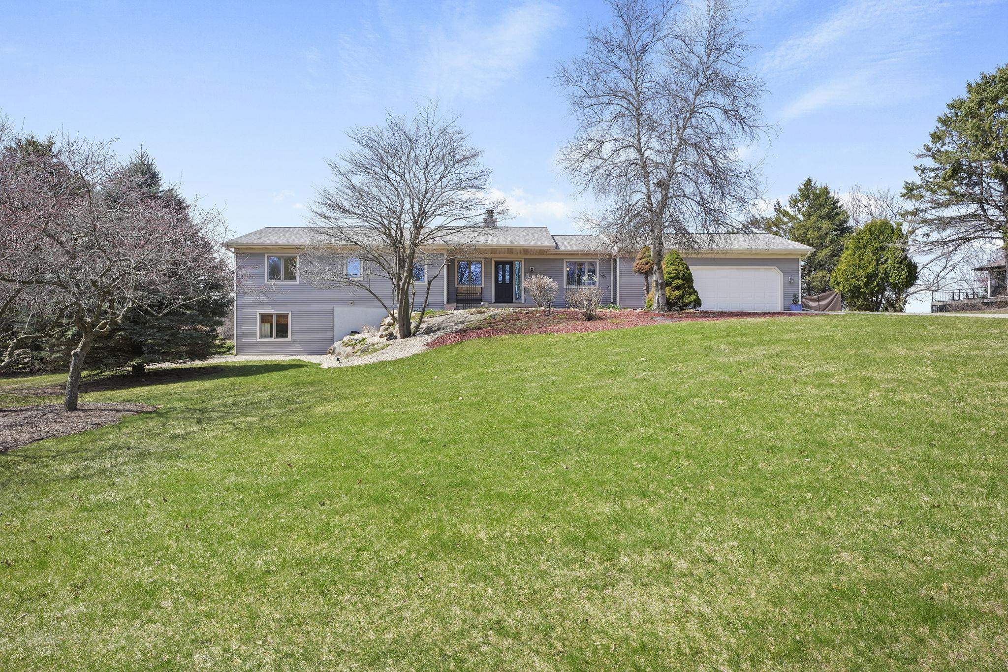 Well-maintained ranch in the Town of Middleton, set on a private 1-acre hilltop lot. The main level offers comfortable everyday living with a spacious living room featuring a wood-burning fireplace, custom built-in cabinetry, and access to the deck overlooking the level backyard. The bright kitchen includes abundant counter space and excellent storage. Three bedrooms are located together on the main floor, including an impressive primary suite. The walk-out lower level adds great flex space with a large rec room, second wood-burning fireplace, retro wet bar, fourth bedroom, and sliding doors to the patio. Main floor laundry is conveniently located in the bright mudroom. Recent updates include newer roof, siding, furnace, A/C, plus refreshed flooring and paint.