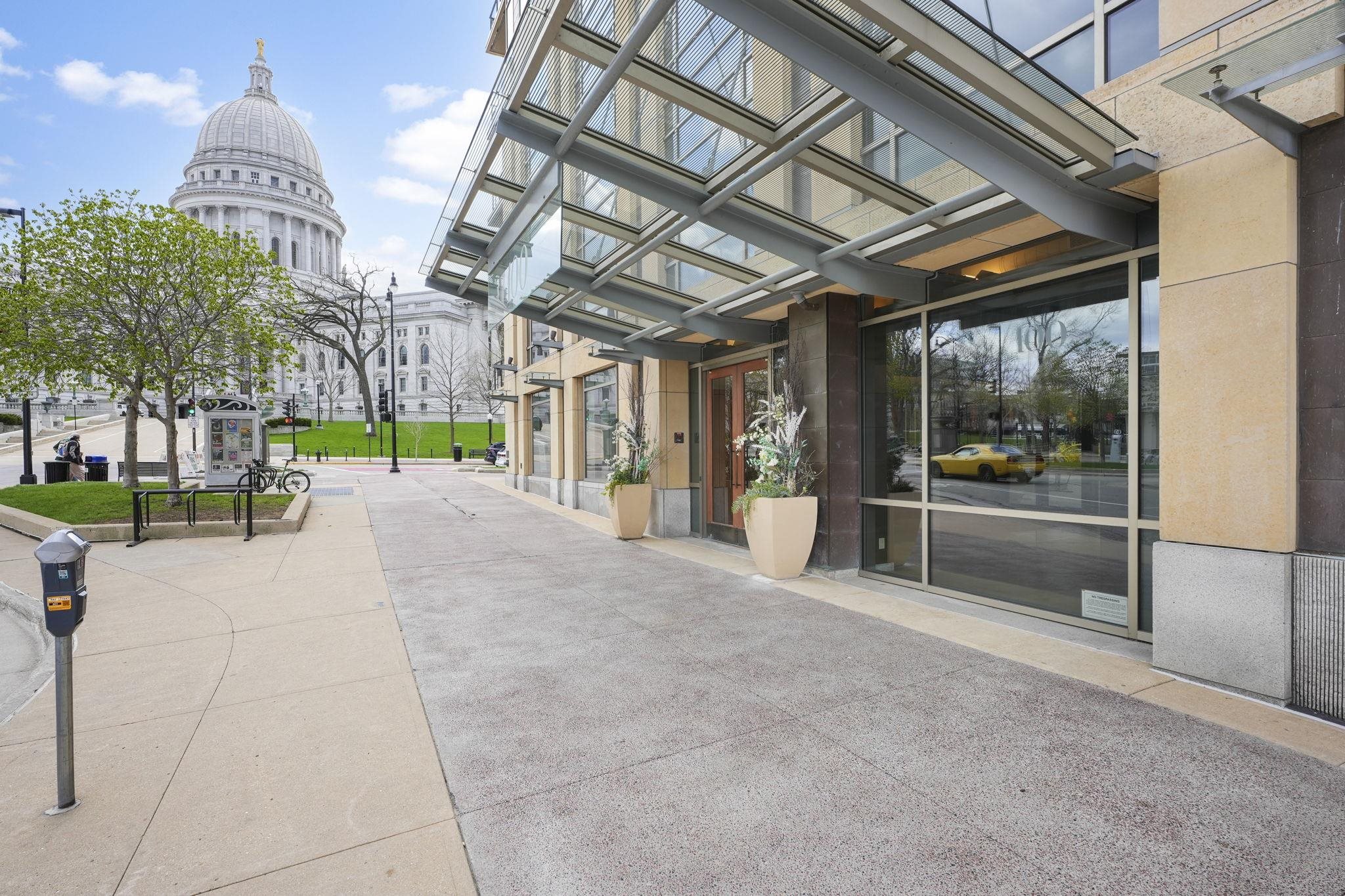 Live in the heart of the Capitol Square with sweeping views of the Madison skyline and direct access to events like the Dane County Farmers' Market and Concerts on the Square just outside your door. This well-designed residence features an open floor plan that creates a spacious, functional layout ideal for both daily living and entertaining. The sun filled primary suite offers Capitol Square views, a two-way fireplace, and a large en-suite bath with an infinity tub, marble surround, and a generous walk-in closet with built-ins. A sizable den connected to a full bath provides flexible space for a home office, library, or second bedroom. Additional highlights include access to a rooftop terrace and two heated, underground parking spaces, making this a rare opportunity for comfortable, convenient downtown living.