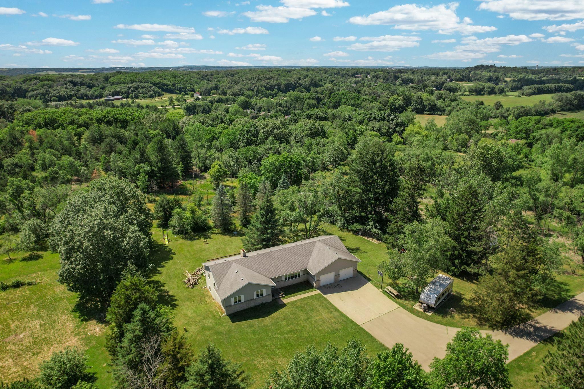 Set on 26.7 scenic acres at the end of a long private driveway, this 4-bedroom, 3-bath ranch offers a rare combination of privacy, elevation, mature trees, wildlife, and an exceptional Town of Verona location. The home and property sit on one of the highest points in Dane County, surrounded by hardwoods, evergreens, open space, and natural habitat with frequent deer, turkey, songbirds, and more. The home features over 2,400 finished sq ft, main-level living, walkout lower level, wood-burning stove, and 3-car attached/tandem garage. Less than 10 minutes to downtown Verona and under 20 minutes to downtown Madison. According to the Town of Verona’s land use plan, the site allows for division into 2-acre buildable parcels, creating compelling long-term flexibility. The house is well built and has been well maintained, but the lion’s share of the value is in the land, acreage, privacy, setting, location, and future potential.