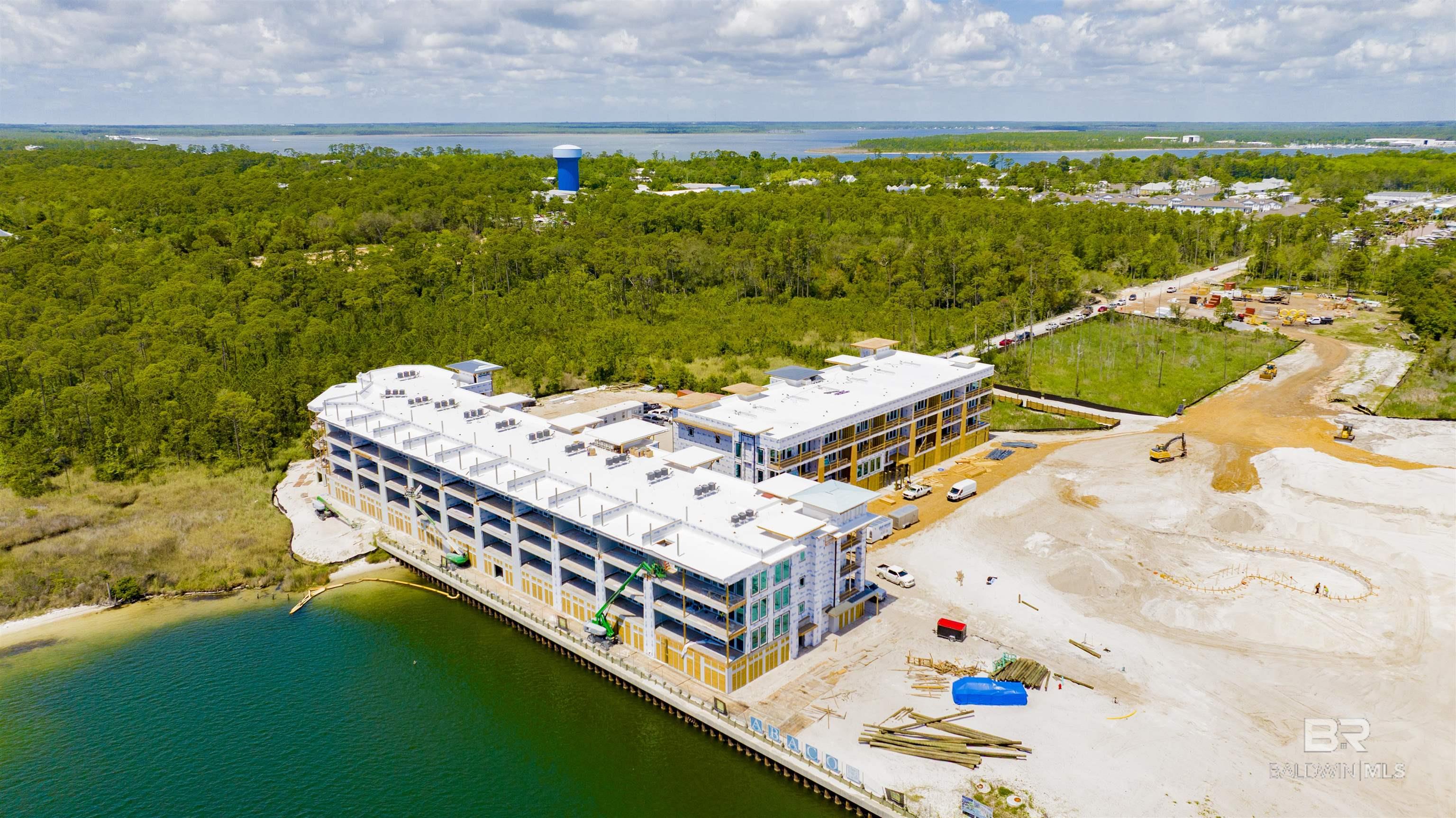 Preconstruction opportunity at Abaco Orange Beach! Elevated water views define the experience from A204 at Abaco, a three-bedroom, three-bath residence positioned in Building A above Terry Cove. The open-concept living, dining, and kitchen areas flow seamlessly onto a covered balcony with a gas grill—an effortless extension of the home for both relaxed daily living and easy entertaining. Inside, engineered wood flooring, solid-core doors, 9-foot ceilings, and a shiplap accent wall introduce a refined coastal character with subtle texture and warmth. The kitchen pairs form and function with quartz countertops, stainless steel appliances, gas stove, and an integrated wet bar with icemaker ideal for hosting. The primary suite features a tiled walk-in shower with glass enclosure, while guest baths are thoughtfully appointed with custom tile finishes. A washer and dryer, dedicated owner storage, exterior storage, and enhanced sound insulation further elevate comfort and convenience. Interiors are professionally curated by Melanie Martin Interiors, blending coastal elegance with livable sophistication. Set across approximately 23 gated acres with 840 feet waterfront along Terry Cove, the community will offer a full suite of resort-style amenities, including a marina with boat slips available for purchase, the Hope Town Green gathering space, waterfront boardwalk seating, a resort pool with cabanas and lazy river, hot tub, fitness center with sauna, pickleball courts, fire pits, covered parking, EV charging stations, and convenient ice stations. A204 combines an expansive water outlook with access to the complete Abaco coastal lifestyle. Completion anticipated Summer 2026!  This is an equitable interest listing where seller is selling only an option contract or assigning an interest in a contract, such as a purchase and sale agreement or a contract for deed. In this situation, the seller does not have legal title to the property, but the equitable interest gives seller the