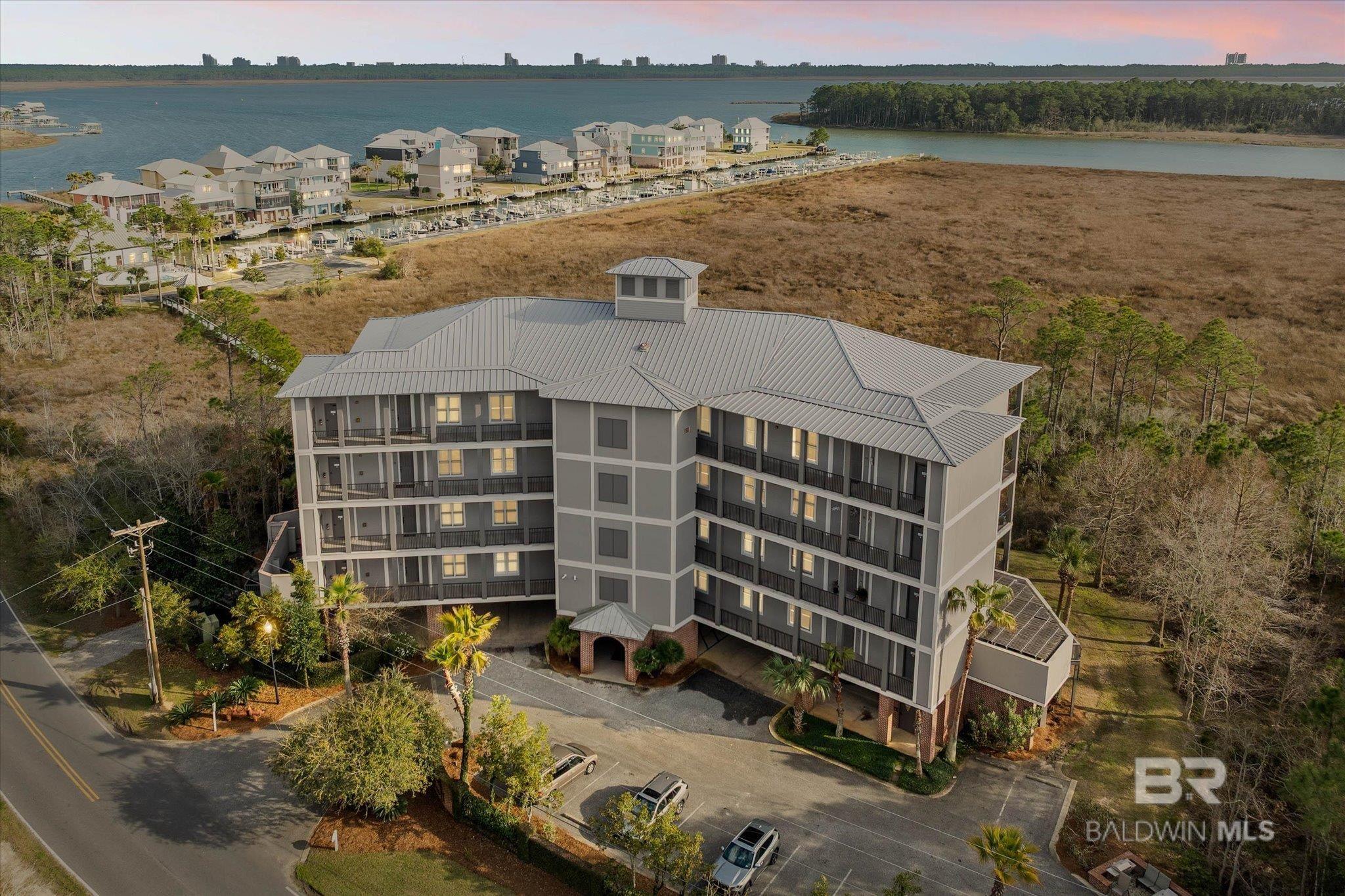 BOATER'S PARADISE!!! This intimate coastal sanctuary, where elegance, love of nature lifestyle awaits, where timeless elegance meets an exceptional boating lifestyle, all within a gated waterfront community. This beautiful three-bedroom, three-bath residence offers a thoughtfully designed living space,created for those who value privacy, quality, and effortless coastal living. Soaring ten-foot ceilings and eight-foot solid wood doors add architecture.The open-concept design flows seamlessly, making it both a relaxed entertaining area and for everyday comfort with a gas fireplace to enjoy on chilly days. At the heart of the home, the kitchen is a chef's dream features Stainless appliances with a gas range, granite countertops, and an inviting breakfast bar—great for slow mornings or gathering with friends after a day on the water. The primary suite is a retreat, offering a spa-inspired bath area with dual sinks, a beautifully tiled walk-in shower, and a soaking tub, private water closet—an inviting space to unwind at day’s end. Two private balconies, accessed through elegant sliding glass doors, gorgeous views and provides a backdrop for sunrise coffee, afternoon breezes, or sunset reflections. Beyond the residence, a thoughtful collection of amenities elevates the lifestyle: a refined clubhouse, resort-style pool and hot tub, state-of-the-art fitness center, and a premier marina complete with a deeded boat slip, offering effortless access to the Gulf Coast’s most scenic waterways. Orange Beach and Gulf Shoes Beaches and convenient shopping are just moments away. This is a rare opportunity to enjoy elevated waterfront living with enormous privacy and the freedom of true boating convenience. Experience coastal living at its finest....Buyer responsible for verifying all measurements and relevant details. Buyer to verify all information during due diligence.