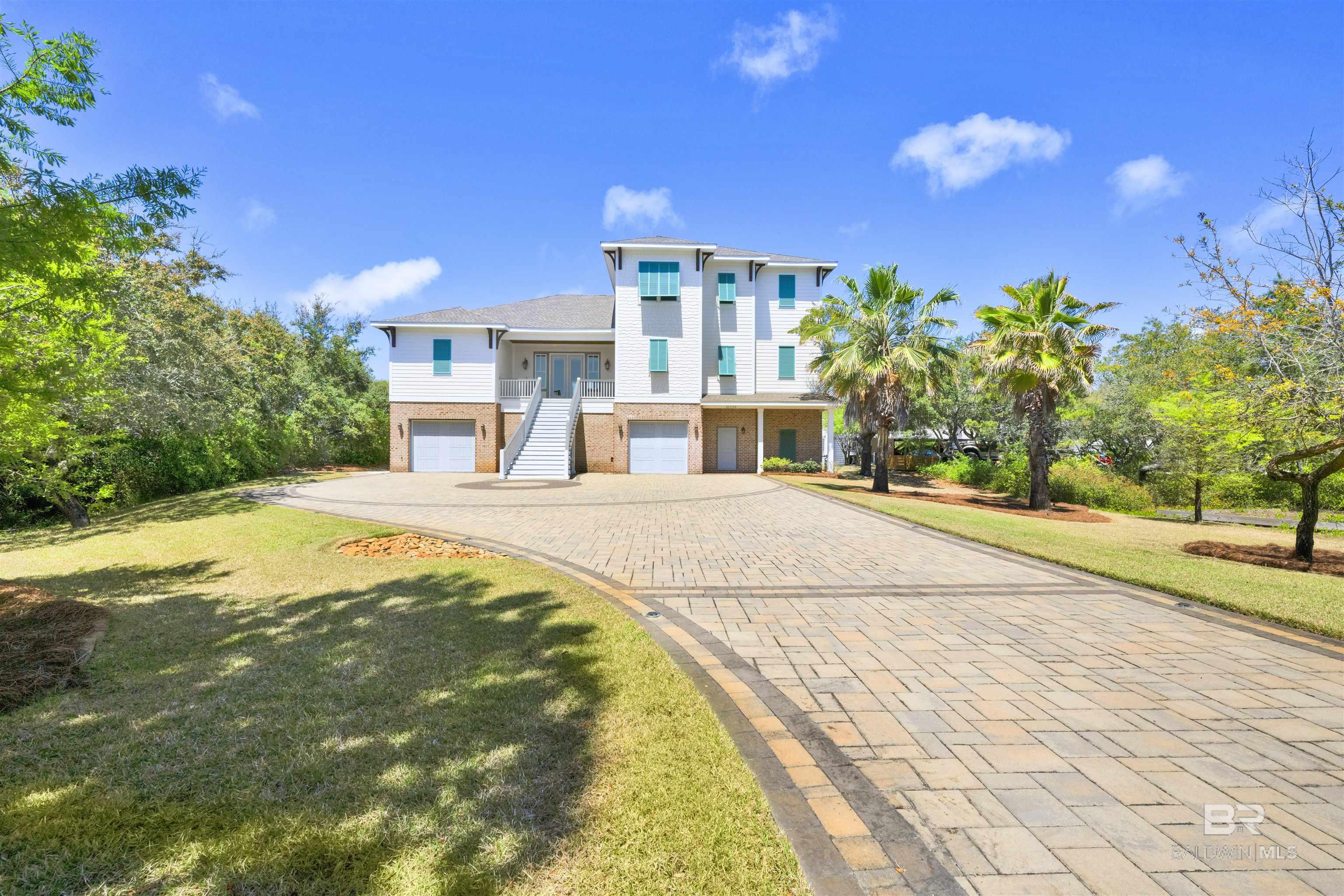 Gold Fortified, custom-built 5-bedroom home located in the gated community of Ono Island, offering beautiful water views. Situated on a unique canal-front lot, this property is designed for both comfort and coastal living. The spacious primary suite features custom cabinetry, a luxury bath with walk-in shower, garden tub, and an oversized walk-in closet. The recently updated gourmet kitchen includes high-end appliances and thoughtful upgrades for cooking and entertaining outdoor living is a highlight of this home with approximately 3,000 square feet of covered porches featuring an outdoor kitchen, dining area, and living space with a fireplace great for enjoying the coastal setting. The large backyard offers additional space for relaxation and gatherings. Additional features include an ELEVATOR, tile flooring throughout and expansive garage space with high ceilings and approximately 2,000 square feet, complete with custom flooring and ample parking.Recent improvements include a whole-house water filtration system, paver additions to the driveway and backyard, lighted driveway and walkway leading to the boat dock, propane fire pit, hot tub, updated front door, geothermal HVAC system on the main floor, Trex front steps, kitchen appliances, renovated laundry room with new sink, granite countertops and fixtures in the primary bath, 85 galloon commercial-grade water heater with instant hot water, elevator battery pack, and propane outdoor grill with 500 gallon propane tank. The private boat dock includes a 10,000 lb boat lift, making access to the water convenient and easy. Schedule a showing today! Buyer to verify all information during due diligence.