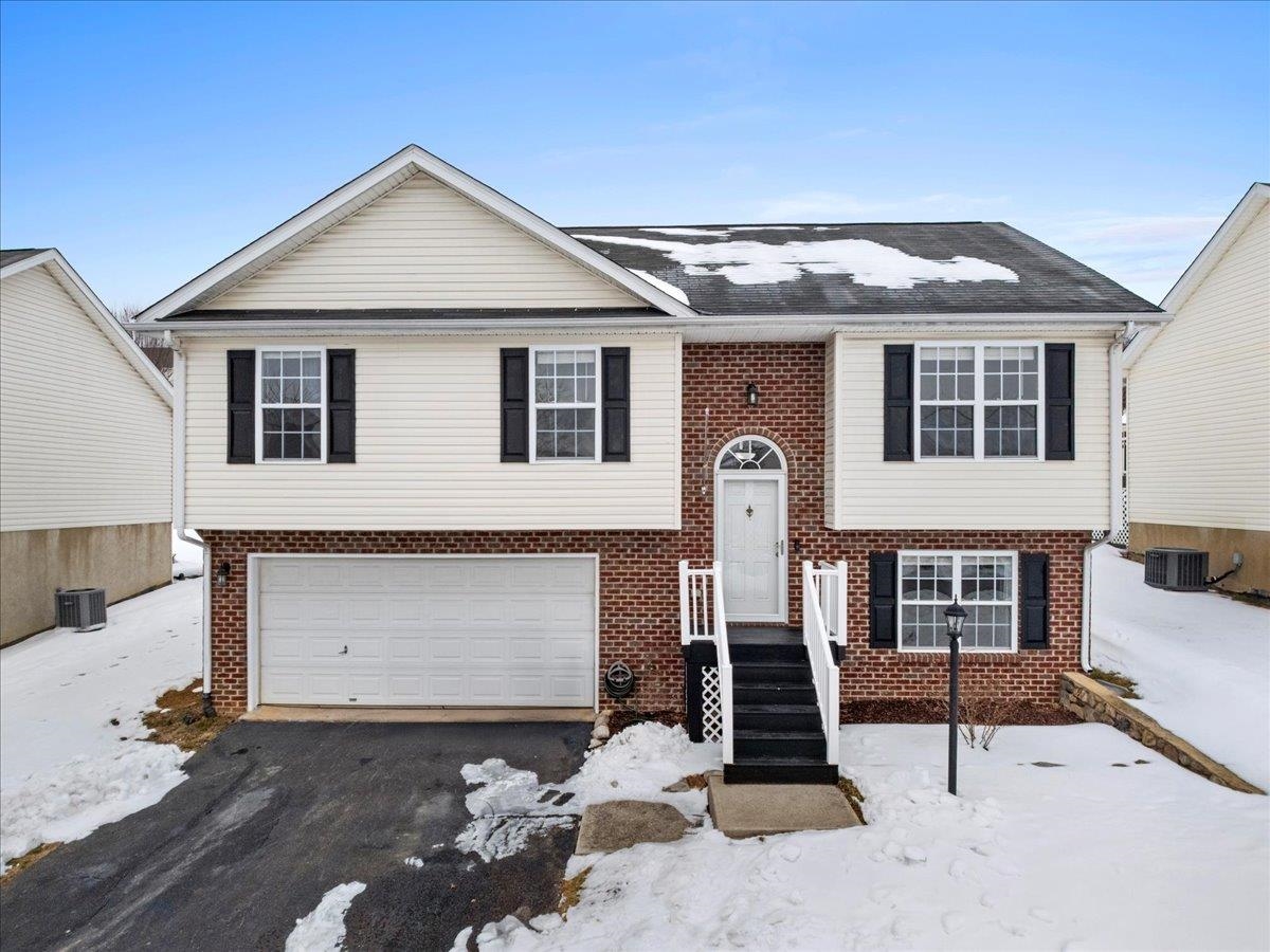 Welcome home to this move-in ready 3BR/3BA split-foyer in the heart of the popular New River Village subdivision! The main level showcases vaulted ceilings and generous natural light, giving the space an airy feel that’s both comfortable and inviting.  kitchen offers refinished cabinets, a tile backsplash, & kitchen island making it a functional and welcoming space for everyday living & gathering. French doors from the dining area open to a back deck & open yard, offering a wonderful setting for outdoor dining, play or gardening. Three well-sized bedrooms are located on the main level, including a primary suite with a private en-suite bath for added comfort. The lower level adds valuable living space with a large rec room, full bathroom, & laundry room. A tuck-under, double attached garage provides convenient parking and additional storage. New HVAC in 2025. Ideally located close to shopping, schools, local amenities, & just minutes from Virginia Tech.