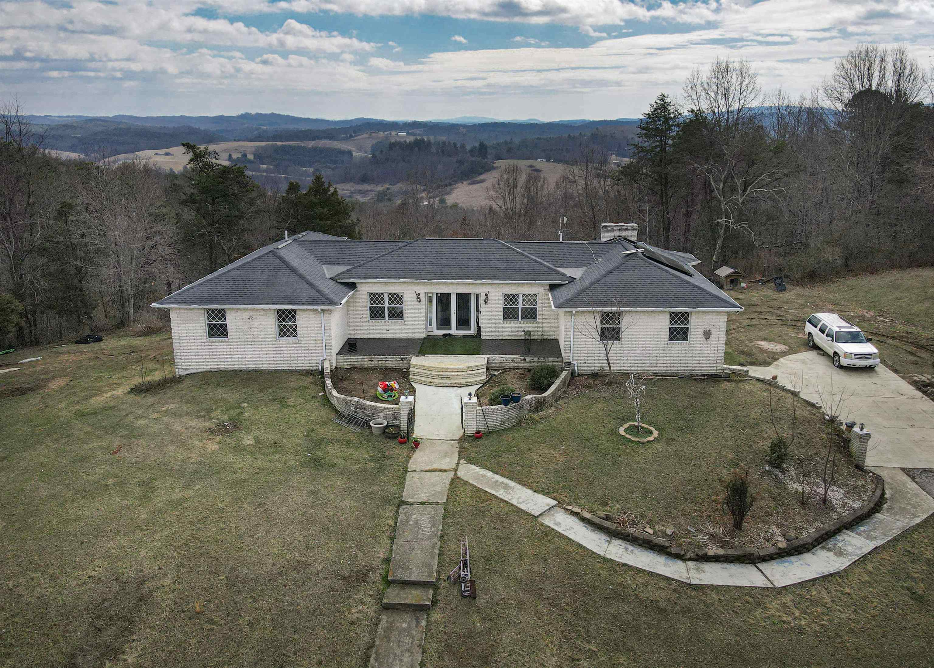 Investors/renovators opportunity! All-brick custom home on 17.5+ private acres in Riner with stunning mountain views from both the front and back. Expansive deck overlooks rolling land with ATV trails and abundant outdoor space. Features a double under-garage plus detached single garage/workshop. Flexible layout offers separate living spaces on each level, each with a full kitchen—ideal for multi-generational living or guests. Quality craftsmanship throughout including arched doorways, built-ins, parquet floors, and Tudor-style windows. Auburn schools, private road setting. All appliances convey. HOME NEEDS TLC and is priced accordingly—an exceptional opportunity to restore a truly well-built home. New heat pump 2021; new solar 2023. Security system, gazebo. Sold AS-IS; inspections welcome.