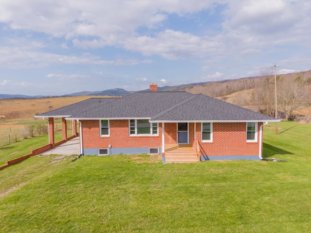 Tucked into the peaceful countryside and surrounded by rolling land and scenic mountain views, this charming all-brick, move-in ready home invites you to slow down, breathe deeper, and truly feel at home. Thoughtfully updated for peace of mind with a brand-new roof and gutters, updated windows, electrical panel box, and water heater within the past two years—blending timeless construction with modern reliability. Inside, sunlight dances across beautiful hardwood floors that flow seamlessly throughout. An open, cozy living room opens to the dining room for easy everyday living. Bright kitchen is functional with room to customize. Flexible family room provides space for relaxing, work, or play. Three bedrooms feature hardwood floors, ceiling fans and ample closets, with a centrally located bath. Full basement for storage or expansion potential. Sprawling 1+ acre enjoys countryside views & opportunities for gardening, outdoor activities or simply enjoying the quiet rhythm of rural life!