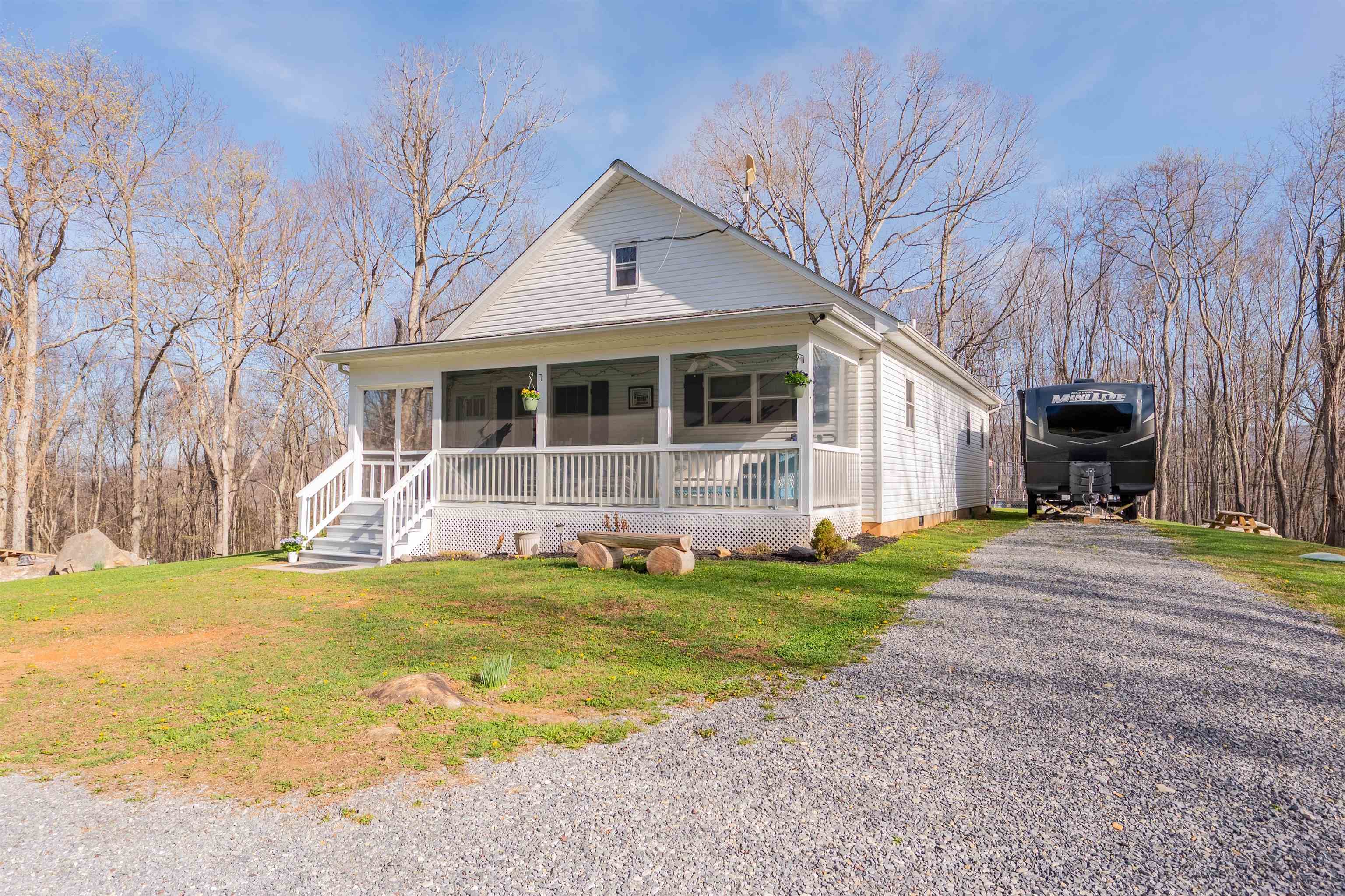Tucked away on 4.35 private acres just 4 miles from town, this charming 2-bedroom, 1-bath home (built in 2016) is the perfect mini homestead with an additional 1-bedroom, 1-bath ADU provides space for guests or rental income. Thoughtfully designed with attention to detail, the main dwelling features 9’ ceilings, laminate wood and hardwood flooring, custom shades, soft-close drawers, and a stylish butler’s pantry. The kitchen shines with retro-inspired appliances, including a Big Chill refrigerator and Northstar range. Enjoy year-round comfort with a heat pump and ceiling fans in every room. Relax on the spacious 28’x8’ covered front porch with ceiling fans, or take in peaceful sunrises and sunsets surrounded by nature and wildlife. The home also offers a large attic for storage, 4G internet, and a security system.  Outside, you’ll find an RV pad, fenced garden with raised beds, and beautiful natural landscaping and a18x8 shed w/electric. Private, serene, and shown by appointment only.