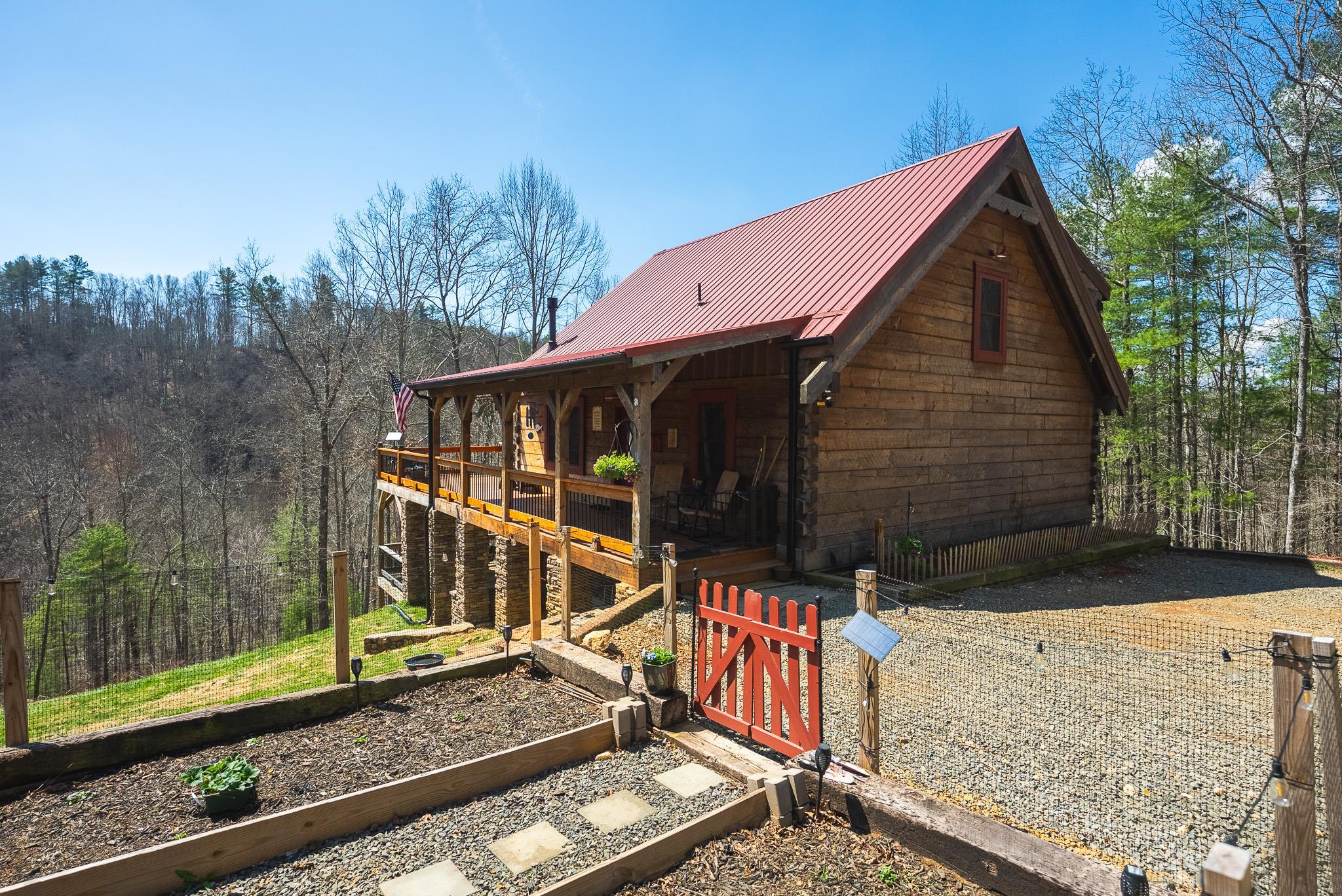 Custom hand-hewn log cabin constructed in 2018 on 6.82 private acres with 300+ feet of frontage on Big Reed Island Creek. This 3 bedroom, 3 bath home offers quality craftsmanship and a beautiful setting just a short drive from Hillsville VA. Main level features an open floor plan with vaulted ceilings, spacious primary suite, and a custom rock wall shower. Loft area includes 2 bedrooms, full bath, and office space. Full basement provides additional bath, laundry, and utility area. A 2 story deck creates excellent outdoor living space for entertaining and enjoying the creekside setting. Property also includes fenced garden area, detached barn/garage with concrete slab floor, fenced livestock area, chicken coop, and cleared road to the water frontage. Access is by private shared drive with recorded road maintenance agreement. Large portion of home furnishings will convey. A opportunity to own a well-appointed waterfront mountain property.