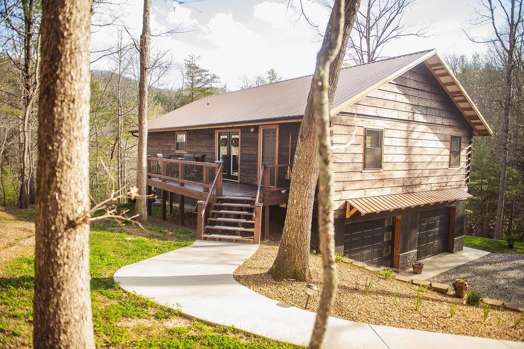 Luxury meets craftsmanship in this one-owner, custom-built cabin in the gated community of New River Oaks! Featuring Shou Sugi Ban exterior, 16’ vaulted ceilings, cedar trim, and an open floor plan with granite countertops and stainless appliances. Spacious owner’s suite with rain shower, guest bath with clawfoot tub, main-level laundry, and office. Energy-efficient with 19 SEER heat pump and new propane furnace. Enjoy outdoor living on two 8’ x 24’ decks overlooking 1.8 acres with creek, new pond, and privacy. Additional highlights include 3 garage doors, concrete sidewalks, stone accents, and 10-year appliance warranties. Access to community common areas. A must-see!