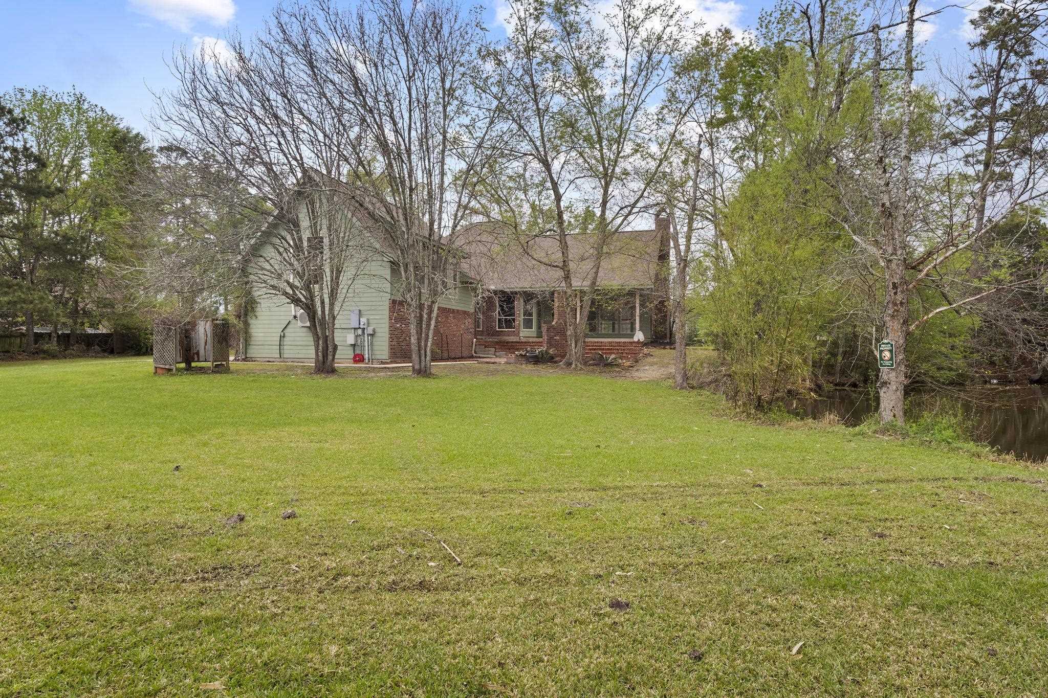 Full view of house exterior from backyard showing green siding and brick accents