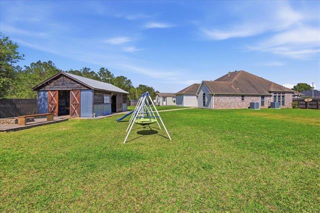 Backyard wide view with swing set and workshop