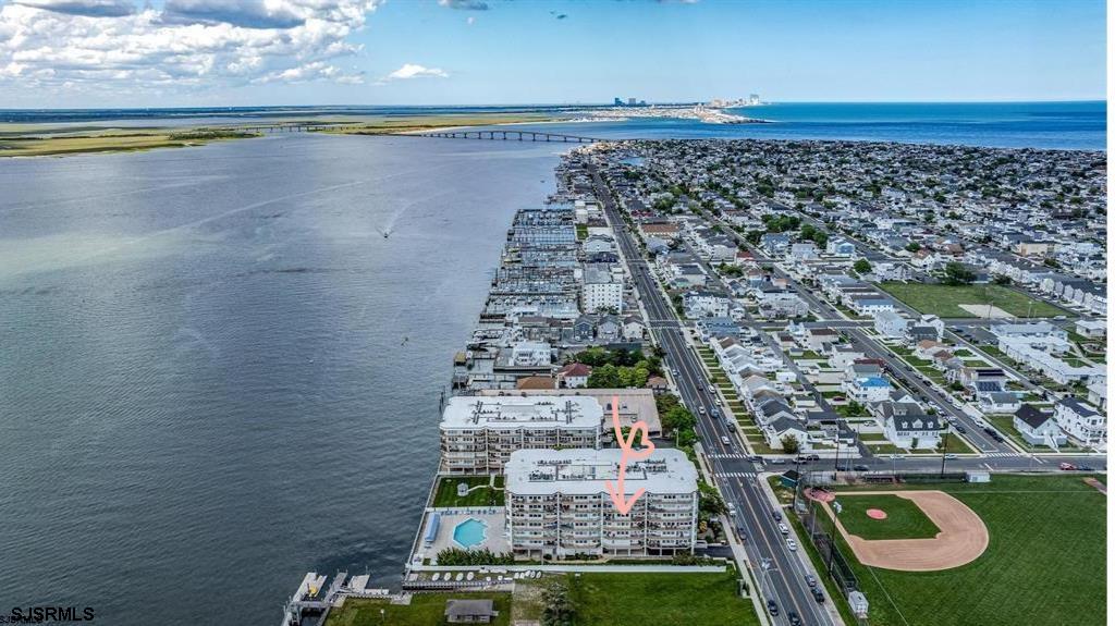 OCNJ PREMIER WATERFRONT COMMUNITY| 500 BAY AVE, UNIT 510 SOUTH   - Sun-drenched, eastern facing, bayfront condo, offering water views and an effortless coastal lifestyle. This beautifully updated 2-bedroom, 2-bath residence (approx. 1,447 sq ft) features a spacious open floor plan with luxury plank flooring, shiplap ceilings, custom lighting, ceiling fans, and a stunning updated kitchen with gorgeous cabinets, granite countertops, glass subway tiles and stainless-steel appliances.  Wake up to shimmering bay views and unwind to unforgettable sunsets with nightly views of the illuminated 9th Street Bridge. Enjoy front-row seats to Ocean City’s iconic Night in Venice parade from your private patio. The generous primary suite offers water views, space for a king-size bed, double closets with custom built-ins, with private bathroom and walk in tiled shower. A well-sized second bedroom with bay views is perfect for guests or a home office.  Located in the impeccably maintained 500 Bay Condominium, amenities include a heated bayside pool, fitness room, secure entry with cameras, reserved garage parking (#94), BBQ grills and new bayfront patio furniture along the north building boardwalk, bike and beach chair storage, Ocean City’s most respected on-site management and maintenance team—plus a warm, welcoming community atmosphere.  Just minutes to the beach, boardwalk, and downtown Asbury Avenue shopping and dining. Ideal for year-round living or a refined seasonal retreat—this is bayfront living at its best.  In accordance with HOA guidelines, 500 Bay has a no pet policy, with the exception of certified service animals and documentation.  Don't delay...call today to schedule your private showing!