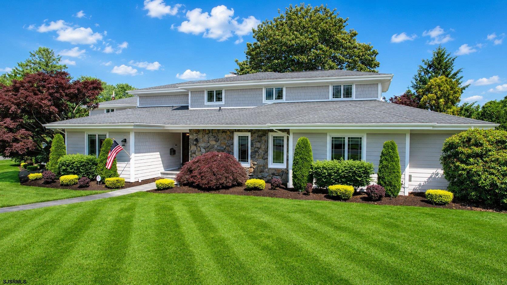 1450 Franklin Boulevard, a truly exceptional estate property set on one of Linwood’s most prestigious and recognizable streets. Situated on a beautifully manicured .53-acre street-to-street lot stretching from Cheltenham Avenue to Balfour Avenue, this stately residence offers an impressive 5,498 square feet of living space, blending timeless elegance with a relaxed coastal lifestyle. The curb appeal is undeniable. Meticulously maintained landscaping, mature plantings, a paver walkway, expansive paver driveway, and side-entry four-car garage create a striking first impression. The garage is thoughtfully designed to accommodate four vehicles with two tandem bays while still providing ample storage space. The home’s attractive & durable Hardie Board exterior, mature landscaping, and impeccable upkeep reflect pride of ownership throughout. Originally built in 1957, the home has been extensively renovated and enhanced by both previous and current owners, resulting in a residence that combines character, quality craftsmanship, and modern amenities. Step through the front door and into a stunning open-concept living space featuring wide plank flooring, thick custom moldings, updated lighting, and abundant natural light. Anderson windows, recessed lighting, and high hats throughout the home create a bright and welcoming atmosphere. The living room and family room are anchored by a dramatic wall of back-to-back fireplaces, creating inviting spaces for gathering and entertaining. The living room showcases a stunning beige marble wall and surround gas fireplace and overlooks the backyard, pool, and peaceful meadow views beyond. The family room, also with a fireplace and views of the yard, flows seamlessly into the heart of the home, an extraordinary chef’s kitchen designed to impress even the most discerning cook. Featuring custom KraftMaid cabinetry with soft-close drawers and doors, built-in organizational storage, furniture quality finishes, granite countertops, and an enormous center island with storage and seating, this space is as functional as it is beautiful. Additional highlights include a six-burner Wolf gas range with dual ovens and griddle, Sub-Zero refrigerator, Bosch dishwasher, farmhouse sink, beverage refrigerator, corner coffee station, serving area overlooking the dining room, shiplap ceilings, skylights, and vaulted ceilings that fill the room with natural light. A wall of windows overlooks the backyard and creates a seamless connection between indoor and outdoor living. The home’s thoughtfully designed floor plan provides an ideal balance of grand entertaining spaces and comfortable everyday living. Multiple gathering areas, private retreats, and versatile bonus spaces create a home that easily adapts to a variety of lifestyles while maintaining a seamless flow throughout. The main level features a private office or den with custom built-ins, a generously sized bedroom with access to a nearby full bath, and two additional spacious bedrooms connected by a Jack and Jill bath. Every bathroom has been beautifully renovated with quality finishes, and closet space throughout the home is exceptional.