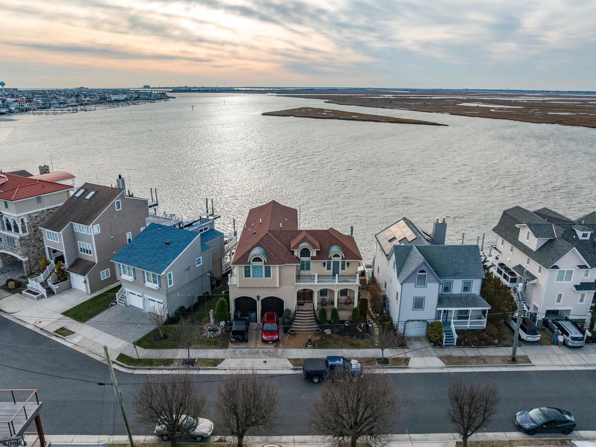 One of the most sought-after bayfront locations in Margate, this exceptional waterfront home offers the ultimate coastal lifestyle. Built in 2012, the residence features 4 bedrooms, 3.5 baths, and approximately 3,300 square feet of living space, thoughtfully designed with quality craftsmanship throughout. Entertaining is effortless in the fully equipped chef’s kitchen, featuring top-of-the-line appliances, ample counter space, and a wet bar. The sun-drenched great room captures stunning bay views and breathtaking sunsets. A massive game room impresses with a built-in wet bar and gas fireplace while the two-car garage offers a car lift and generous storage space. The well appointed primary suite provides the perfect retreat, complete with a spa-like ensuite bath and plenty of closets. Boasting unmatched waterfront views and sunset-filled evenings, this home delivers every amenity for life on the water — from a 16,000-lb capacity boat lift to an outdoor kitchen — and will not disappoint.