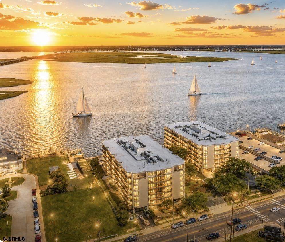 TAKE YOUR BREATH AWAY AT 500 BAY!  Wake up to breathtaking sunrises, distant ocean views, the Atlantic City skyline, and refreshing coastal breezes from this beautifully renovated, fully furnished 2-bedroom, 2-bath luxury condo at 500 Bay, 608 South, one of Ocean City, NJ’s premier bayfront communities. Offering 1,364 SF of open-concept living, this sophisticated coastal retreat features shiplap accents, warm-toned LVP flooring, abundant natural light, and a stunning kitchen with white cabinetry, glass subway-tile backsplash, granite countertops, and stainless-steel appliances. The spacious primary suite includes a walk-in closet and private bath access, while the second bedroom and full bath are thoughtfully separated by the family room for added privacy. Three exterior doors open to your private patio, creating effortless indoor-outdoor living and spectacular sunrise views from virtually every room, including the ocean, Ferris wheel, and Atlantic City skyline.  Enjoy an exceptional resort-style lifestyle with a heated bayfront pool, waterfront boardwalk with new outdoor furnishings, two BBQ areas, fitness center, two clubhouses, bike and beach chair storage, additional floor storage, trash chutes, landscaped grounds, and incredible front row seats to  Ocean City’s iconic Night in Venice festivities. A reserved covered garage parking space #18, plus additional top-floor guest parking, adds convenience. Major association improvements include new roofs on both North and South Buildings, bulkhead reinforcement, parking garage upgrades, facade improvements, and balcony inspections.  Perfect as a year-round residence, luxurious second home, vacation getaway, snowbird retreat, or Jersey Shore investment property, this fully furnished condo offers an easy lock-and-leave lifestyle. Enjoy award-winning beaches, the Ocean City Boardwalk, downtown dining and shopping, marinas, boating, fishing, parks, and nearby golf at Great Bay, Linwood Country Club, Atlantic City Country Club, and Seaview Golf Club. Beautifully renovated. Fully furnished. Unforgettable views. Exceptional amenities. Your Ocean City, NJ baydream is waiting at 500 Bay #608 South! Schedule your private showing today.