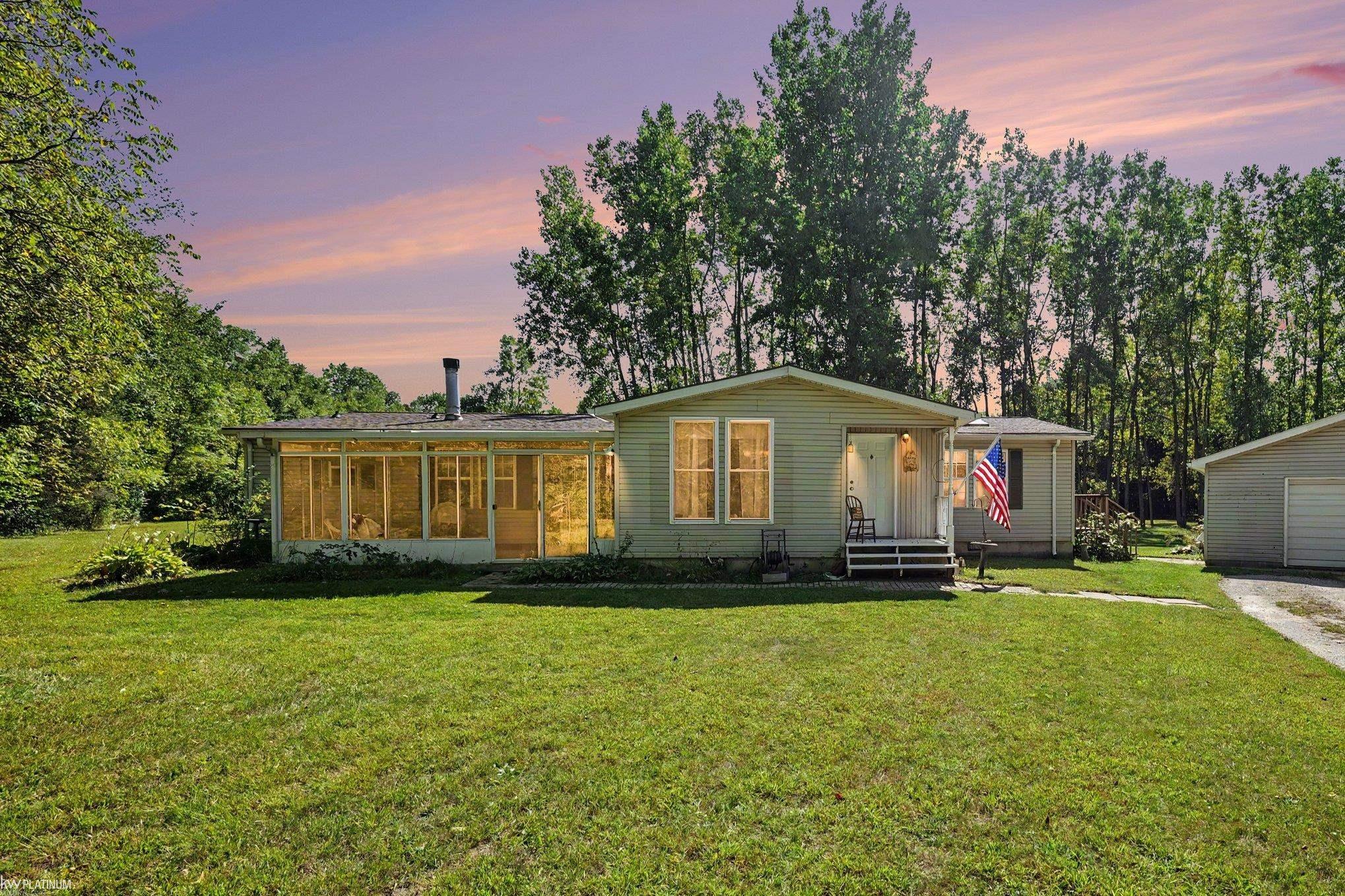 ** OPEN HOUSE THIS SUNDAY 9/20/26 FROM 12-3PM ** Welcome home to your own Private Retreat!  Tucked away at the end of a winding driveway, you'll find a spacious ranch nestled on 6.6 Beautiful acres surrounded by mature trees....offering peace, privacy and plenty of room to enjoy the outdoors.  This property offers an ideal location being situated on a Paved road with Natural Gas and located within the highly sought-after Armada School District.  With just over 2000 sqft of living space all on one level, this 3 bedroom, 2.5 bath ranch offers a comfortable and functional layout.  The centrally located kitchen overlooks one of the two living areas that features a natural stone fireplace, adding warmth and character to the space.  The home also offers a designated dining area, and a bonus room off the back with access to the deck overlooking this Beautiful property.  The spacious primary bedroom includes a private full bath and a walk in closet.  Laminate Oak flooring runs throughout most of the home.  A front porch/sunroom offers an additional space to relax and enjoy the peaceful setting.  Outside, the property truly shines with and impressive 1200 sqft barn featuring a metal roof, a workshop with heat , A/C, water, and       220-amp Service. Whether you need a space for hobbies, projects, equipment, or storage this barn offers incredible versatility.  A 2.5 car detached garage adds extra room for storage and parking. All appliances are included along with a 1 year Home Warranty. Recent updates include New roof on home and garage (2016), Newer Furnace, A/C, and HWT.  If you have been looking for a Ranch, acreage, privacy, and a Barn, this property offers the opportunity to enjoy it all in one place...Schedule your showing today!!