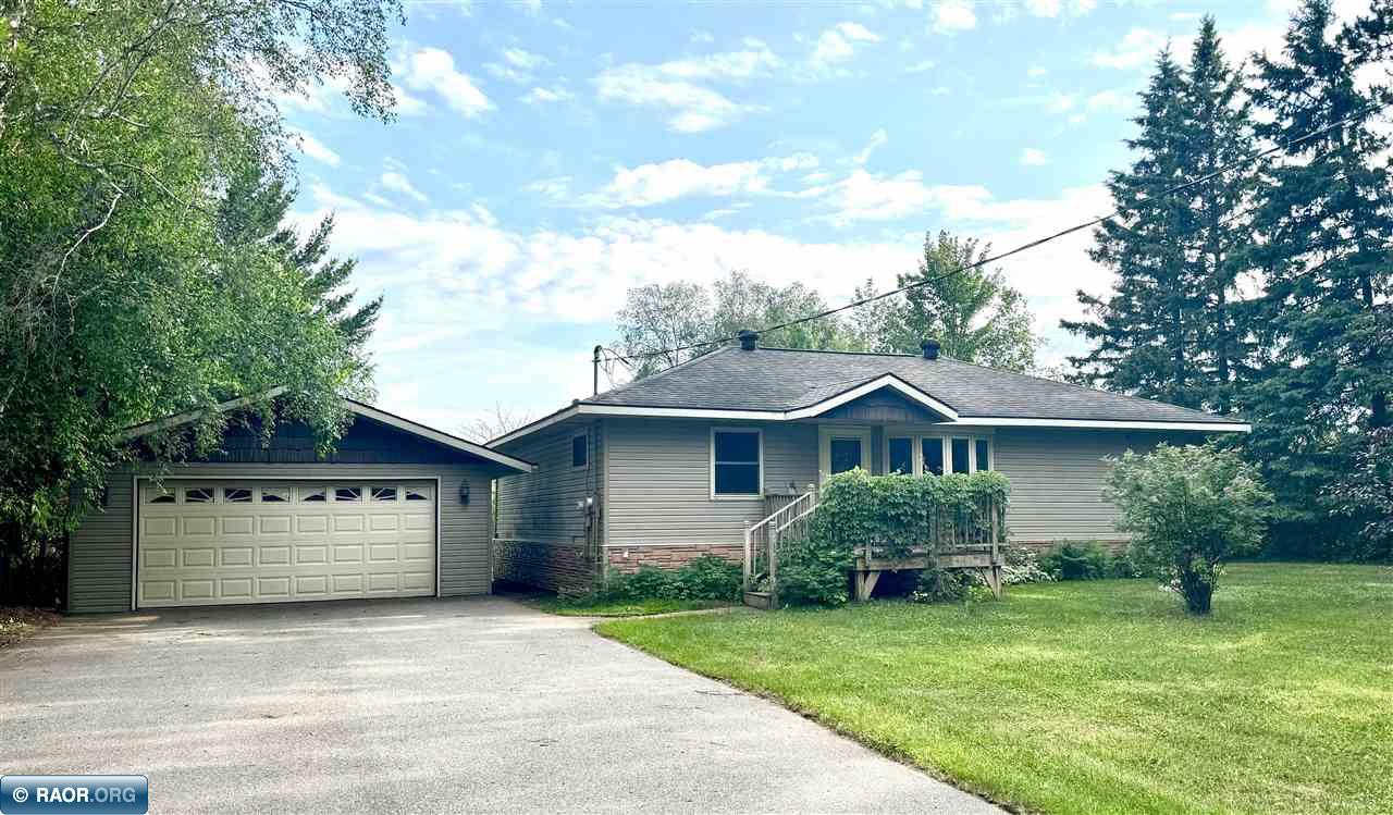 Enjoy peaceful lakeside living in this 2 bed, 1.5 bath home nestled on a beautifully wooded 1 acre lot with 116 feet of shoreline on Long Lake in Fayal township. A gentle slope leads to the water, while the spacious lakeside deck offers the perfect place to relax, entertain, and take in the view. Inside, you'll find hardwood floors, an updated kitchen with granite countertops and ample cabinetry, a refreshed full bath with convenient main floor laundry, and a sauna for unwinding after a day on the lake. The detached 2 stall garage and additional storage sheds provide plenty of space for vehicles, tools, and lake toys. Whether you're searching for a year round residence or the perfect weekend retreat, this property offers comfort, privacy, and everything you need to enjoy lake life.