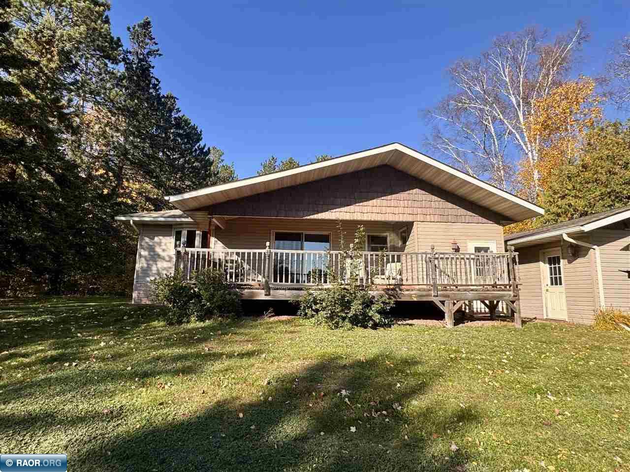 Enjoy peaceful lakeside living in this 2 bed, 1.5 bath home nestled on a beautifully wooded 1 acre lot with 116 feet of shoreline on Long Lake in Fayal township. A gentle slope leads to the water, while the spacious lakeside deck offers the perfect place to relax, entertain, and take in the view. Inside, you'll find hardwood floors, an updated kitchen with granite countertops and ample cabinetry, a refreshed full bath with convenient main floor laundry, and a sauna for unwinding after a day on the lake. The detached 2 stall garage and additional storage sheds provide plenty of space for vehicles, tools, and lake toys. Whether you're searching for a year round residence or the perfect weekend retreat, this property offers comfort, privacy, and everything you need to enjoy lake life.