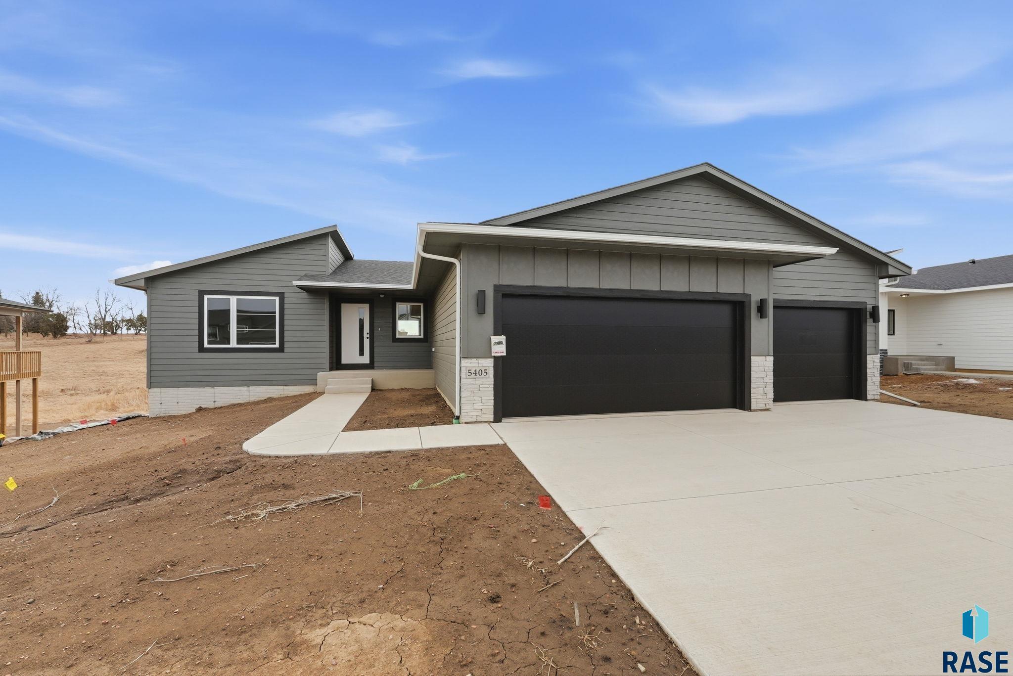 This stunning ranch-style home offers 1,500 finished sq ft with 3 bedrooms, 2 baths, and main-floor laundry. The open layout is perfect for entertaining, with vinyl plank flooring throughout the hallway and living room. A drop zone with bench and hooks sits just inside the garage entry, along with a laundry room featuring cabinets and a hanging rod. The galley kitchen includes a large island, walk-in pantry, and flows into the vaulted living and dining areas. A swing door leads to the covered deck—ideal for outdoor gatherings. The split-bedroom layout provides privacy, with the primary suite offering a tray ceiling, walk-in closet, and tiled walk-in shower with linen storage. Two additional bedrooms with large windows share the main bath. The unfinished walkout basement offers room to grow with space for two more bedrooms (each with walk-in closets), a full bath, and an oversized family room. Garage includes hot and cold-water spigots for added convenience. Photos for marketing purposes only. School boundaries subject to change—please verify with the district.