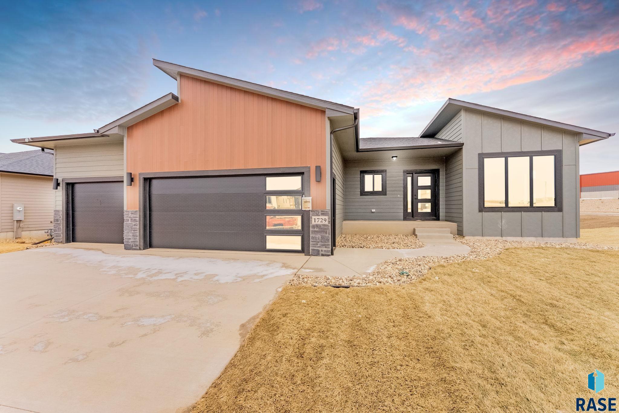 This stunning ranch-style home boasts a thoughtfully designed, fully finished layout with 2,805 square feet of stylish living space. The main level offers 3 bedrooms and 2 bathrooms, including a luxurious master suite with a trey ceiling, tiled walk-in shower, dual-sink vanity, and oversized walk-in closet. Rich LVP flooring flows throughout the open-concept living room, anchored by an elegant electric fireplace, and into the gourmet kitchen featuring upgraded selections, a walk-in pantry, and an oversized island. The dining area opens to a covered composite deck with cedar rail and sleek metal spindles—perfect for relaxing or entertaining. The finished walkout lower level adds 2 more bedrooms, a full bathroom, a spacious family room with a wet bar, and direct access to the backyard. The insulated, textured, and painted garage, along with high-end finishes throughout, make this home truly move-in ready.