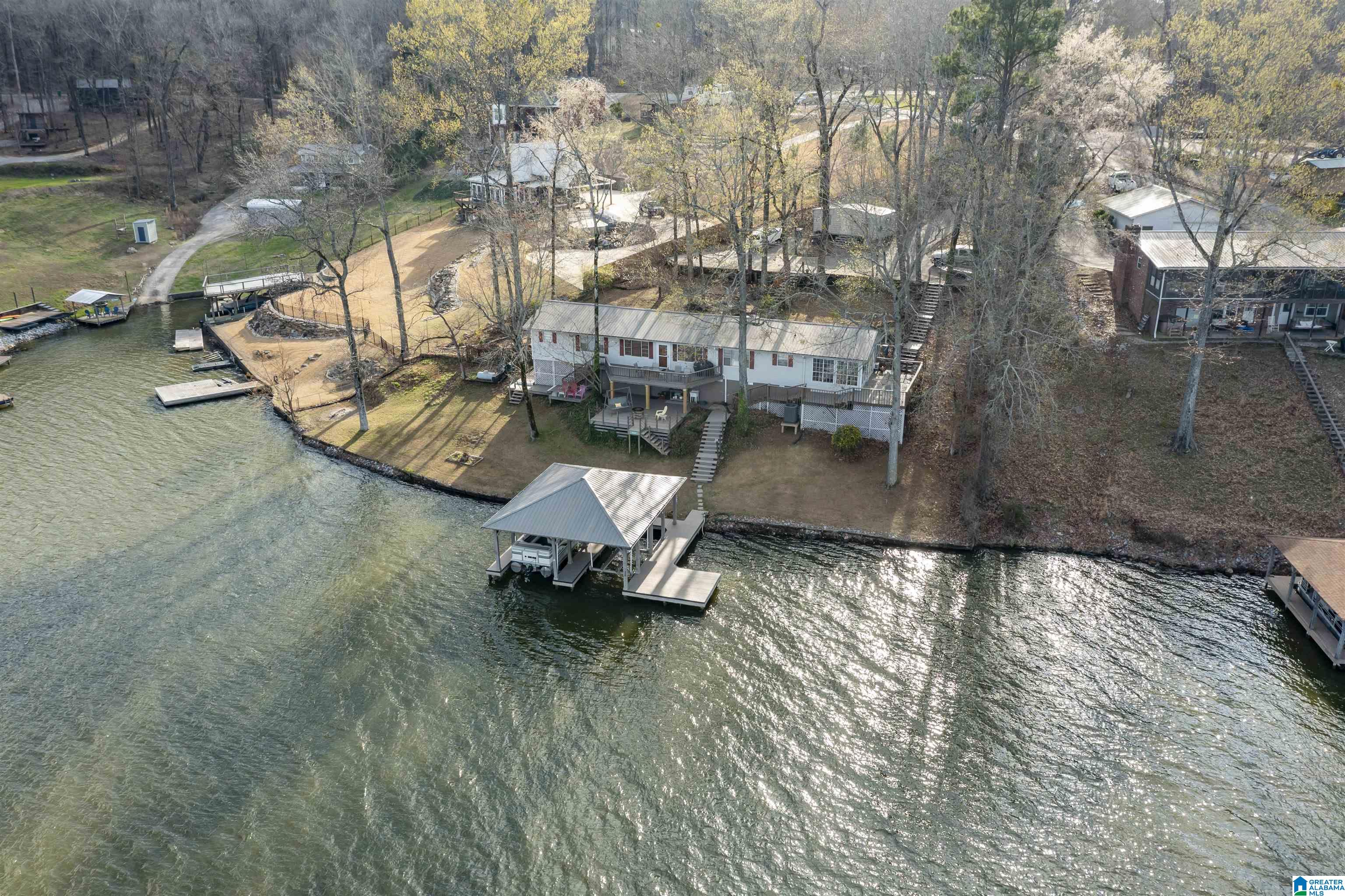 RARE FIND! One-Level MAIN CHANNEL Lakefront living on Lay Lake with MAJESTIC PANORAMIC views & deep year-round water! This private & peaceful retreat in the desirable Shelby Shores community offers breathtaking views inside & out. Well-maintained 3-bedroom, 2-bath home features spacious Living Room with gas FP, Kitchen plus dedicated office. Home thoughtfully expanded to add walk in closets & Sunroom to capture incredible lake views. Sunroom opens to 3 levels of decking—perfect for entertaining or relaxing by the water. Outside features a large 2-stall boathouse with 2 lifts & separate sunning/fishing pier. HVAC approx. 2 yrs; metal roof 6-7 yrs. Pump system in place. Wired, insulated workshop with A/C; perfect Man’s cave. Incredible opportunity to update & customize your own lakefront retreat on one of Lay Lake’s most desirable settings! Shelby Shores community offers many activities; Book Club, Angelfish Bible Study,  Pot luck dinners, Worship services & other activities.