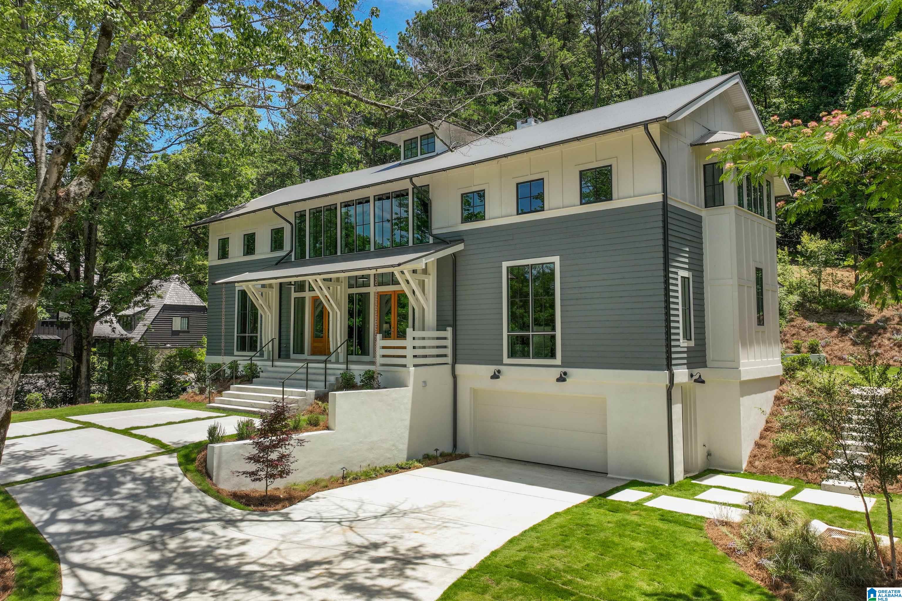 This modern, one of a kind home sits atop Murray Hill in Homewood and offers a perfectly flat backyard with hillside woods and terraces beyond. White oak flooring throughout, Sierra Pacific steel windows spanning 2 stories. Open kitchen with marble counters, GE monogram appliances & column fridge/freezer, custom steel & glass open shelving, ample cabinetry in kitchen & separate pantry. Light filled living areas, oversized garage with EV charger. Primary suite has vaulted ceilings, gorgeous windows that frame the private back yard, expansive bath & closet space with a laundry chute to the basement laundry room. Upstairs has three large bedrooms with walk-in closets and beautiful baths, a 2nd laundry room, plus a huge den space with views of front & back yards. Basement level has a large mudroom/drop zone, cozy den/media room with built-in shelving & wired for theater & sound, private bedroom & bath (office), plus large laundry room with storage and utility sink. More in agent notes.