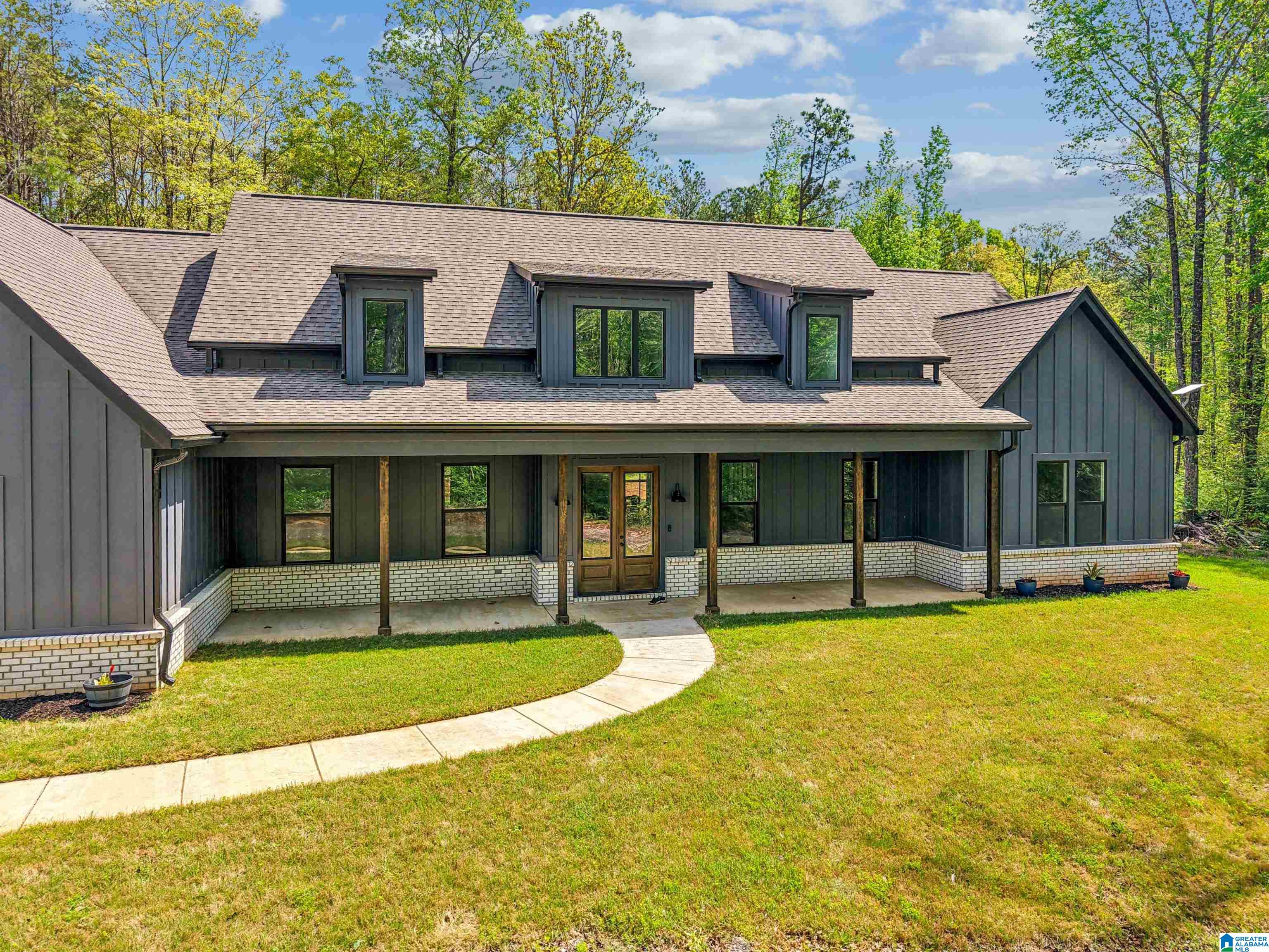 Tucked into the trees and approached by a winding private drive, this 20+ acre retreat in The Ranches at Shelby Lakes is where privacy, space, and possibility come together. The thoughtfully designed, newly built, all one level, 4-bedroom, 3.5-bath home features soaring vaulted ceilings, an open, airy layout, and seamless indoor-outdoor flow.  The home and land offer a rare blend of move-in ready comfort and long-term vision. Outside, the land tells the real story.  20+ acres, mature trees and access to a shared lake perfect for relaxing, fishing, kayaking…property opens the door to what can be your private family compound, hobby farm, recreational retreat or future expansion. There’s room to build, grow, and create something truly special.  Home is wired for generator, garage has floor drain for car wash, Starlink to remain; TVs, washer, dryer do not convey.