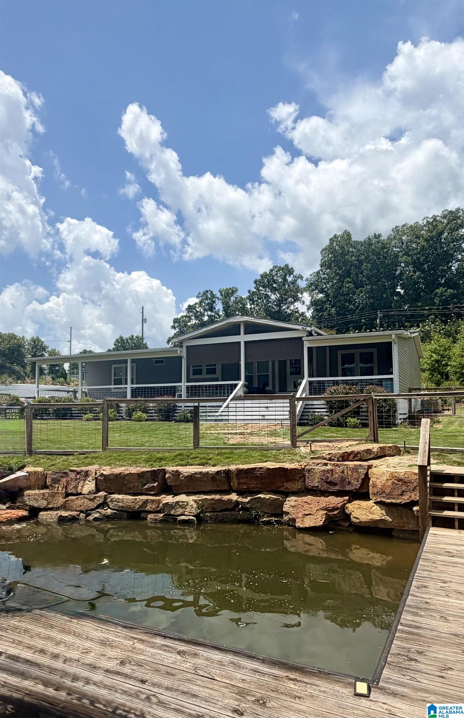 Come enjoy lake living on beautiful Lay Lake/Spring Creek Area. This 3 bedroom 2 bath home features a functional layout with an open living/dining area, ideal for everyday living or weekend getaways.  The split bedroom design offers privacy, while all the natural light creates a warm and inviting atmosphere. Outside, you'll find ample space for parking. There is a huge covered outdoor deck perfect for taking in the beautiful view. This beauty has tons of space!! The extra office/study is a bonus! There is a Beautiful rock seawall and the same rocks outline the entire driveway! The landscape lighting accents the beautiful rocks. There is also an existing sprinkler system. This home can be mortgaged & has a HUD compliant engineer certificate for the foundation. APCO has also previously approved a boathouse! Don't miss out on this one!!!!