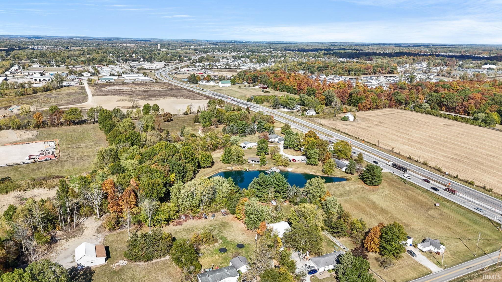 Aerial overview of property's location with a nearby body of water and a tree filled landscape