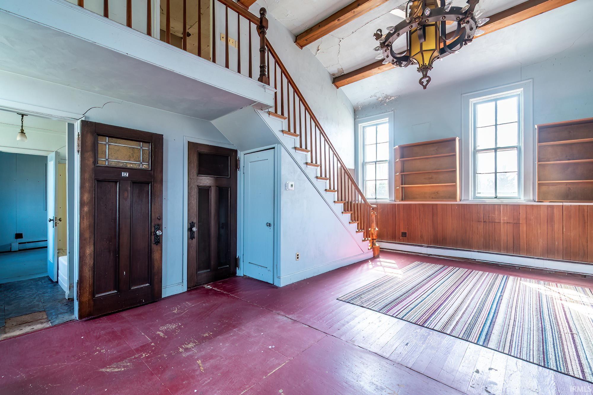 Entryway with beam ceiling, baseboard heating, a baseboard radiator, and hardwood / wood-style floors