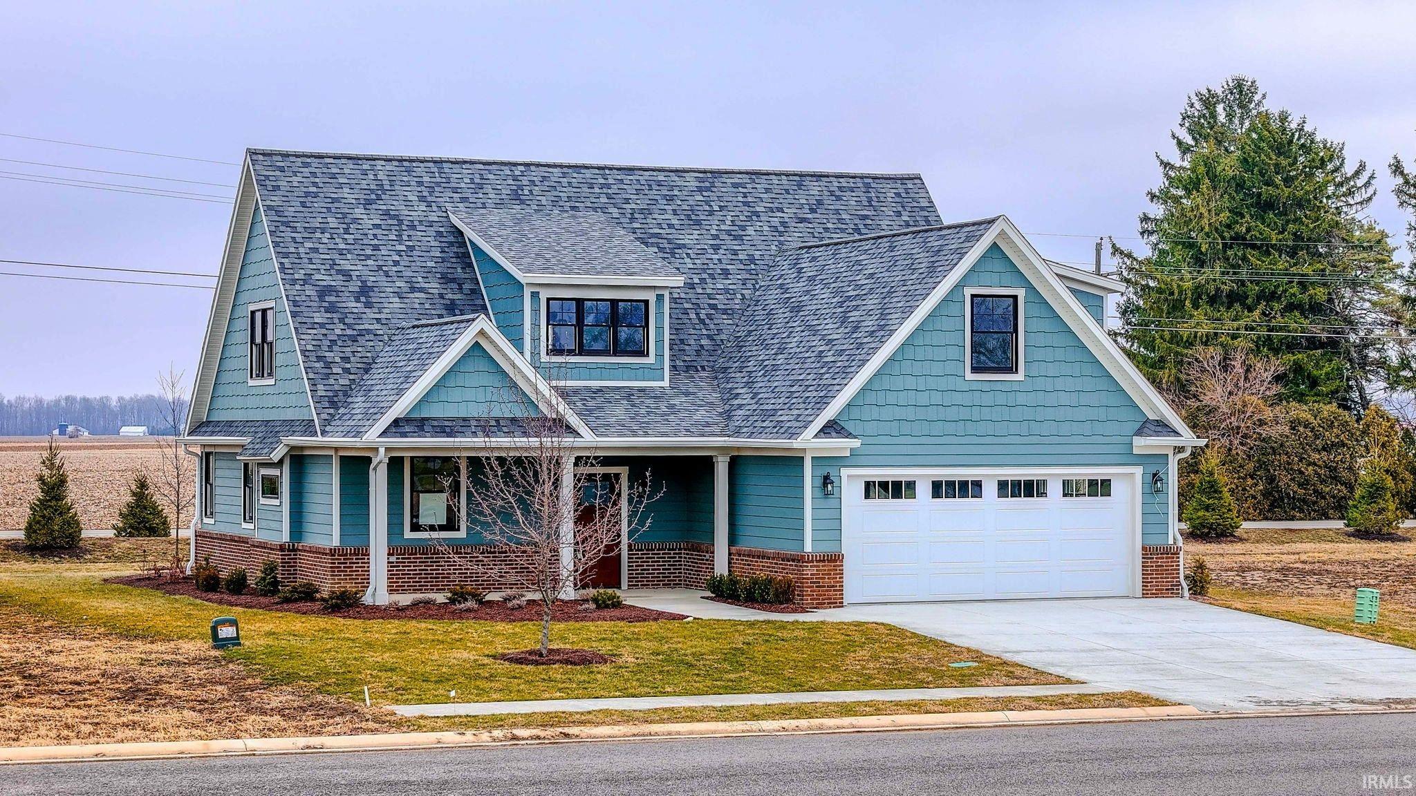 View of front facade with roof with shingles, a front yard, concrete driveway, a porch, and a garage