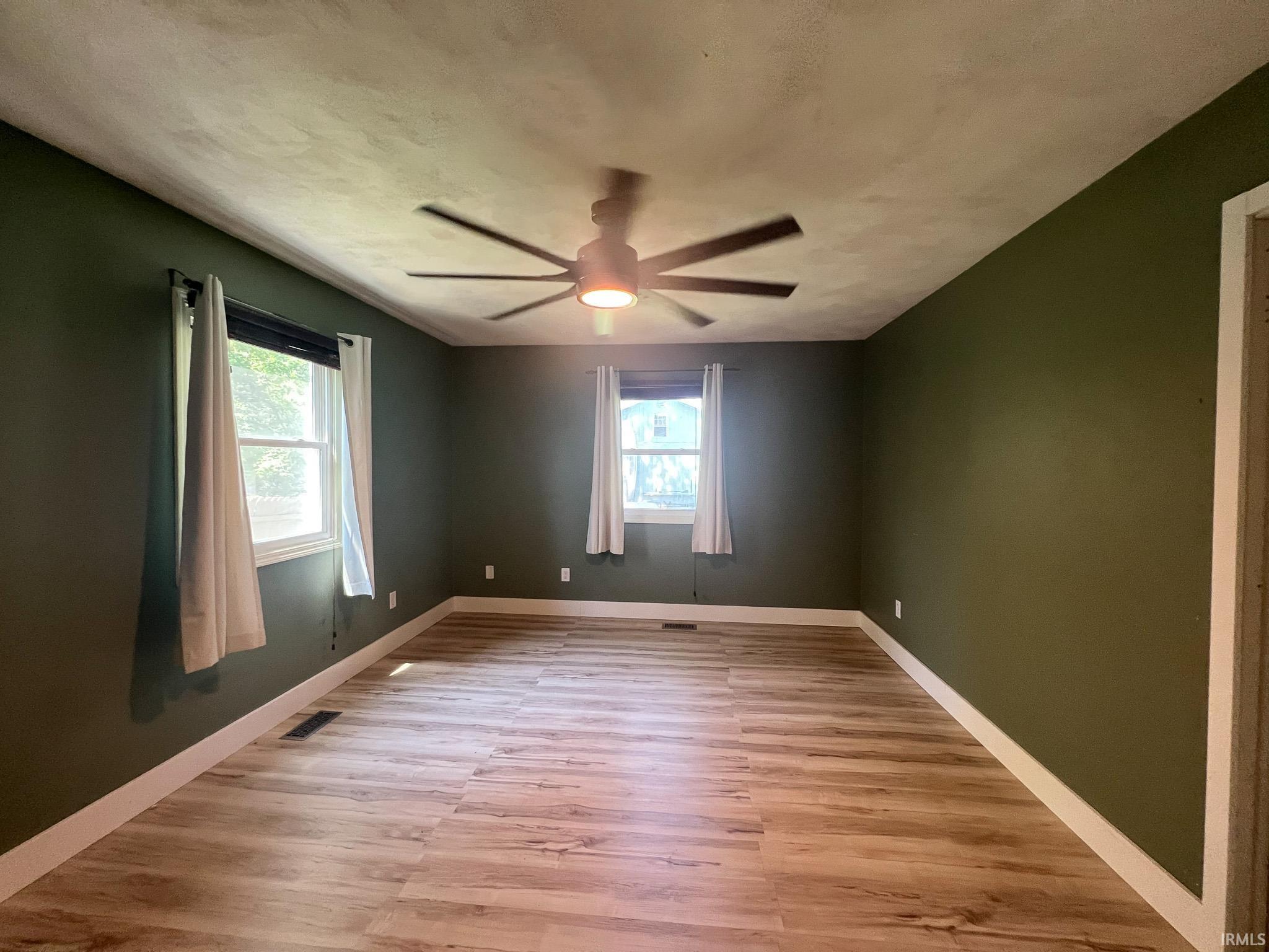 Master bedroom featuring light wood-style floors, a ceiling fan, large closet