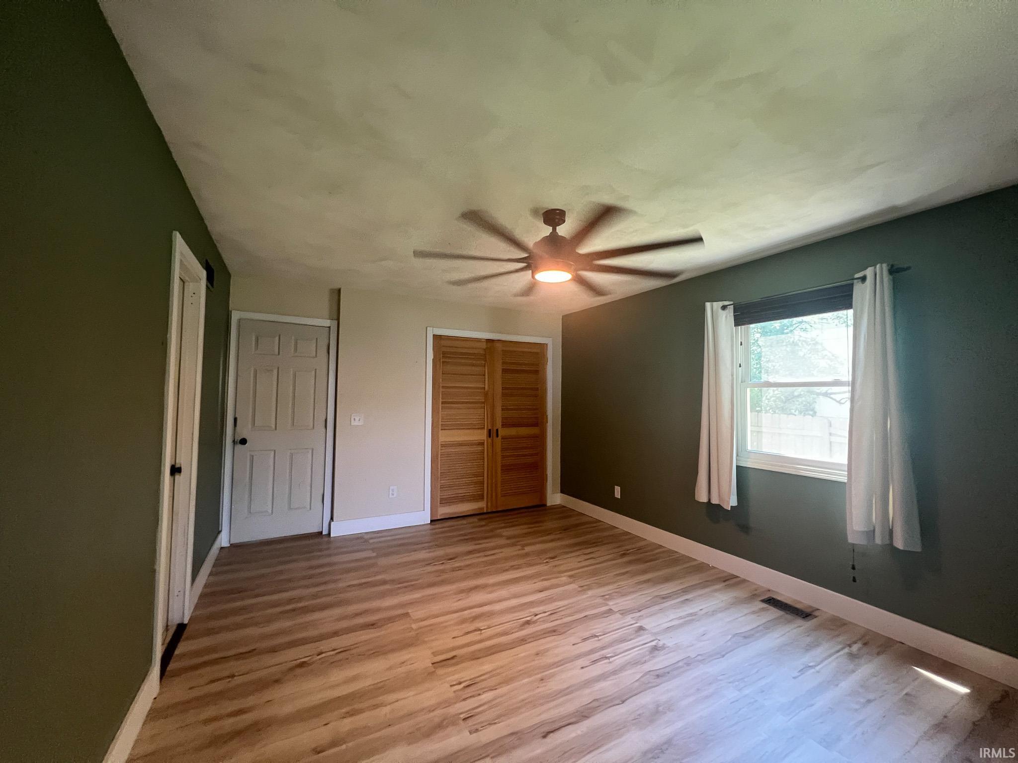 Master bedroom featuring light wood finished floors, a large closet, and ceiling fan