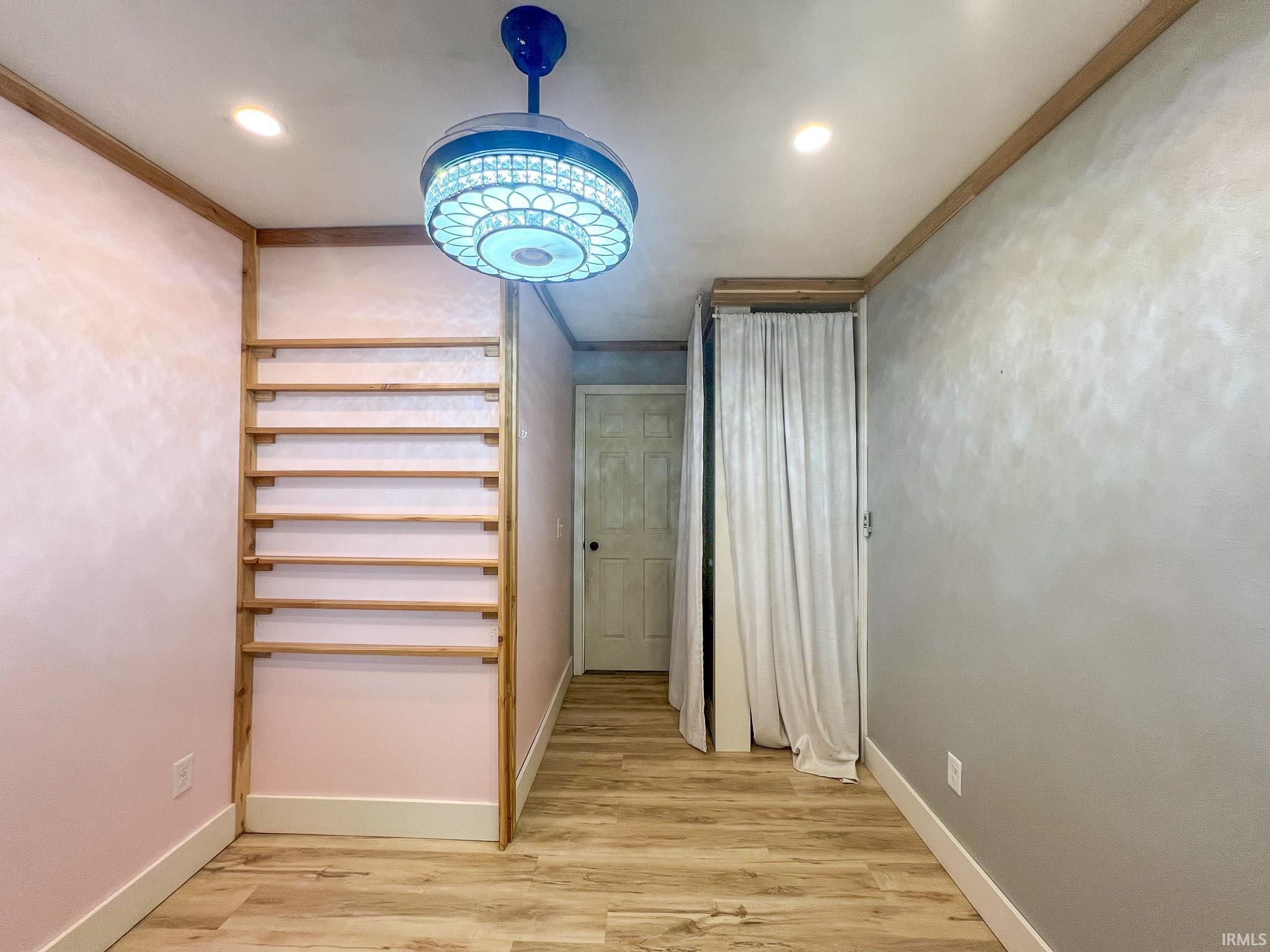 Bedroom 3 converted into an in-home salon featuring light wood-style floors, crown molding, and a closet