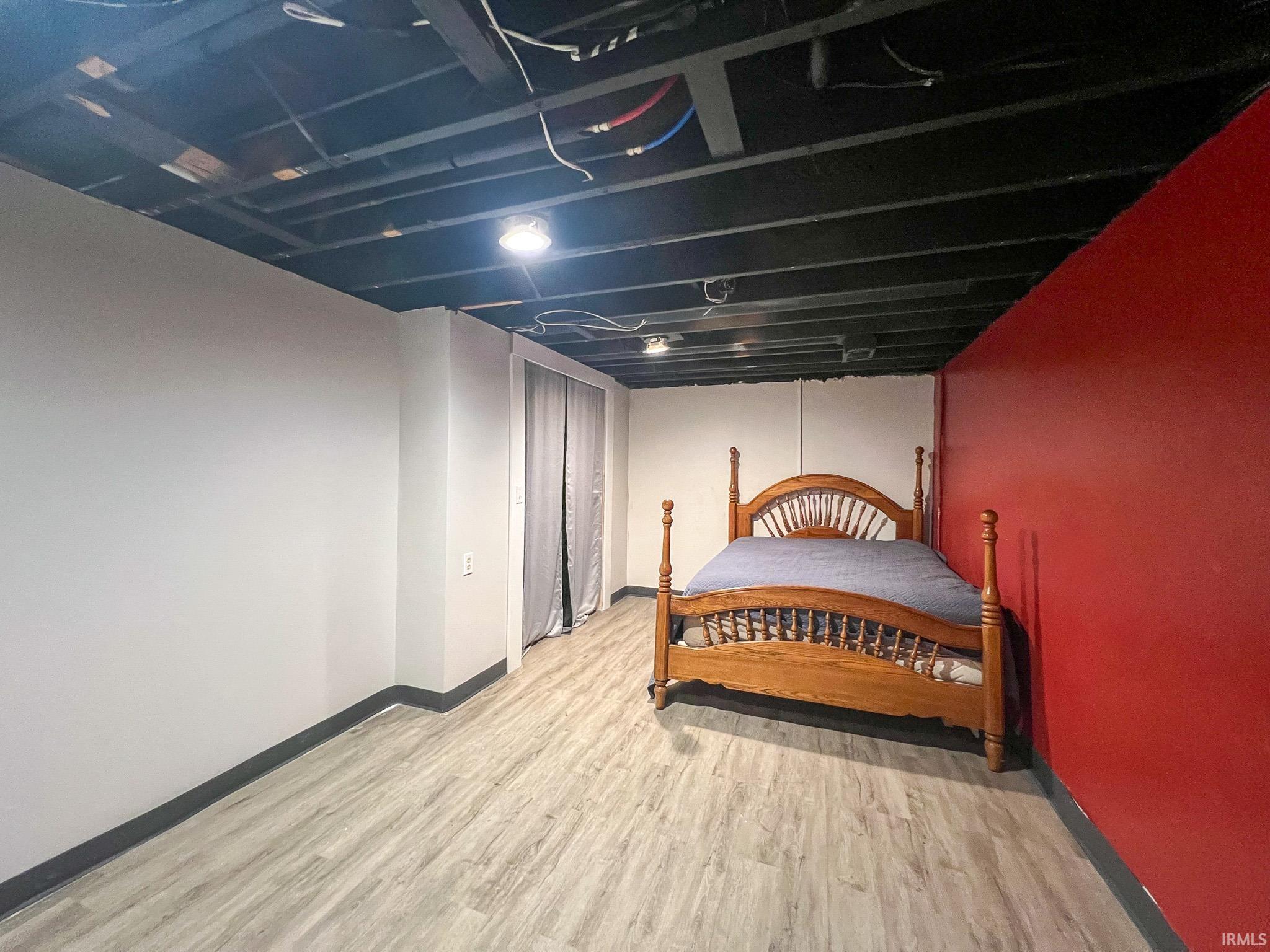 Potential bedroom in basement featuring light wood-style floors and closet. No egress window.