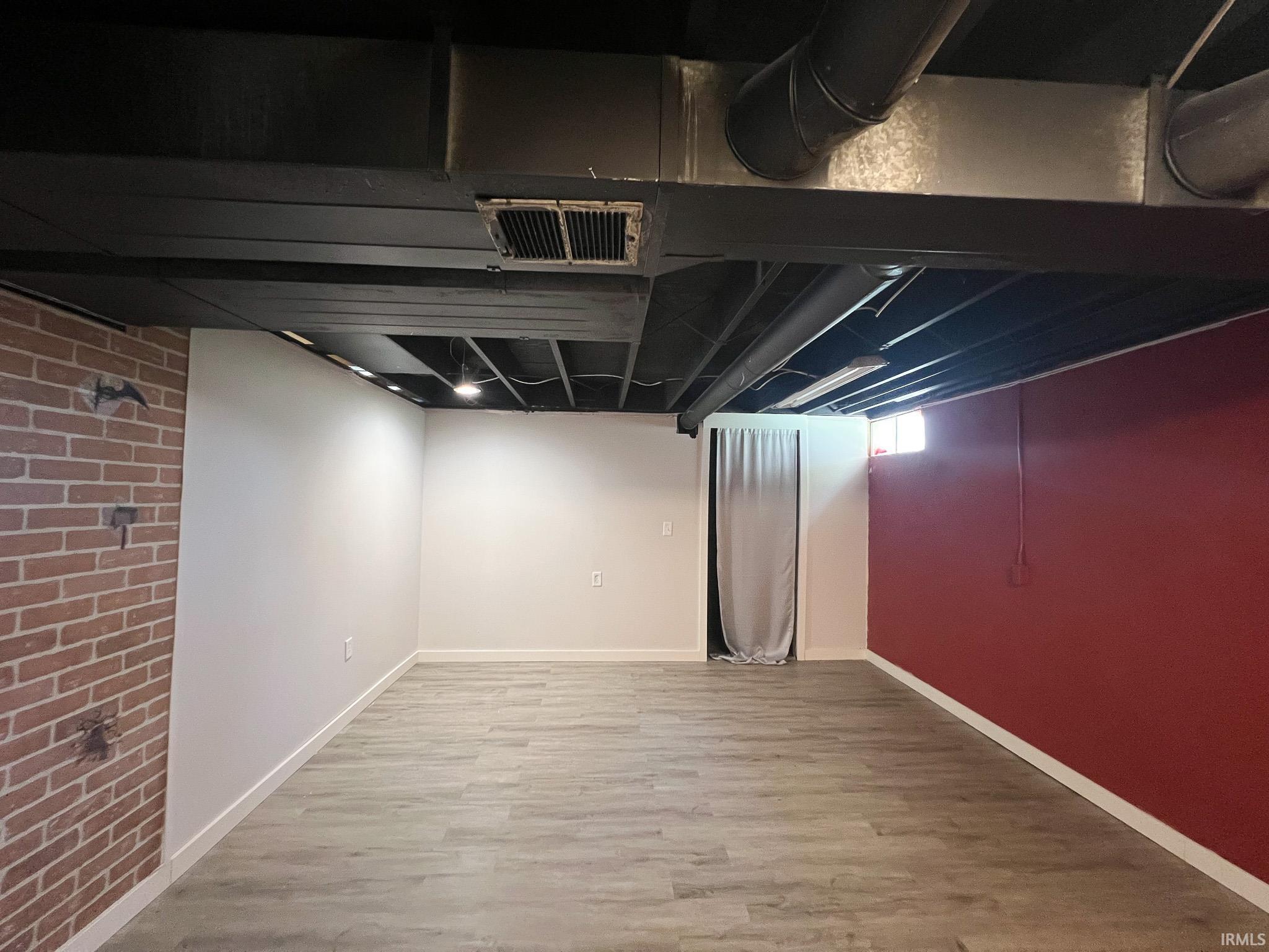 Potential bedroom in the basement with light wood-style floors and closet. No egress window.