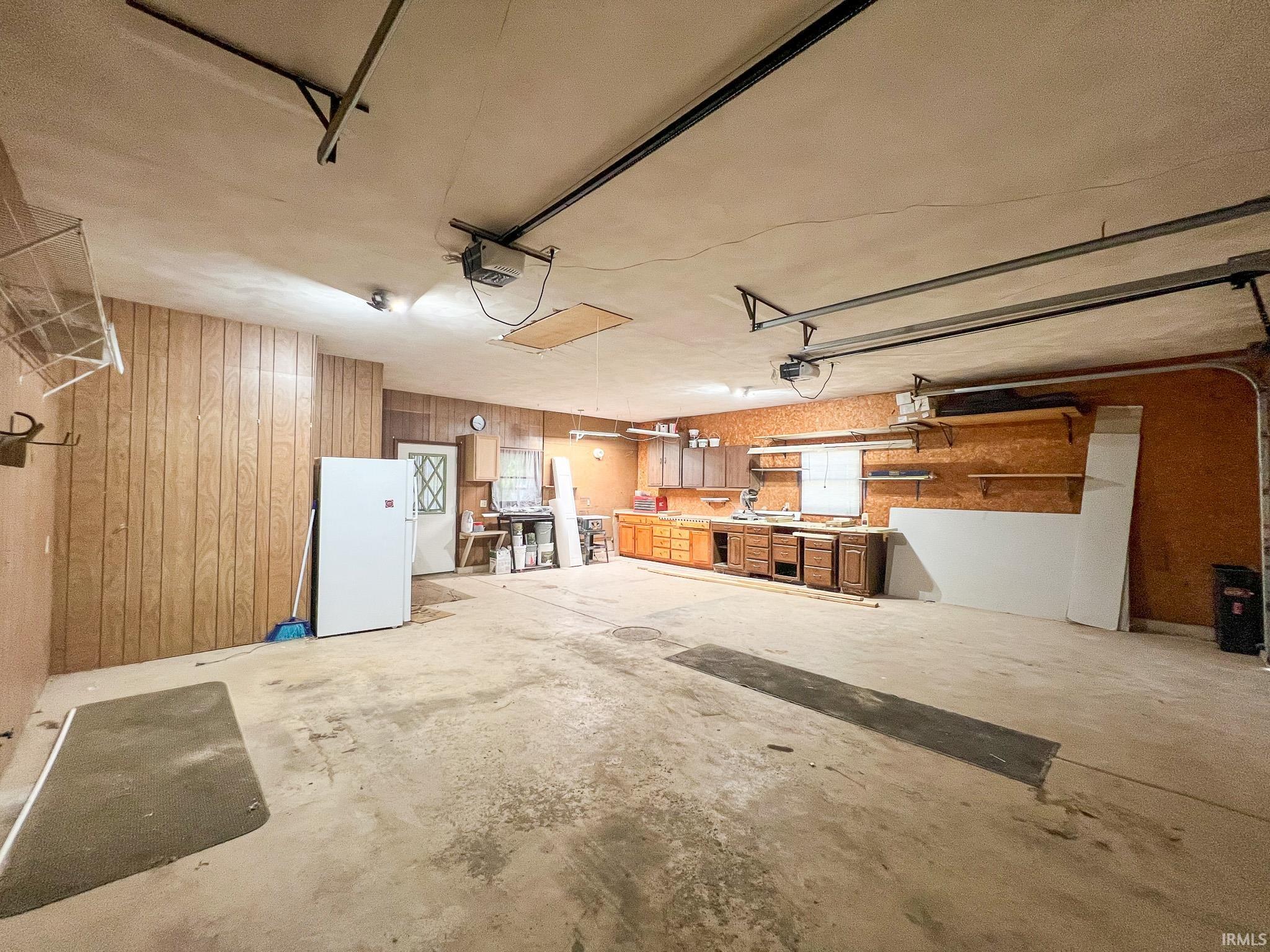 Garage featuring large work bench area, cabinets and a garage door opener