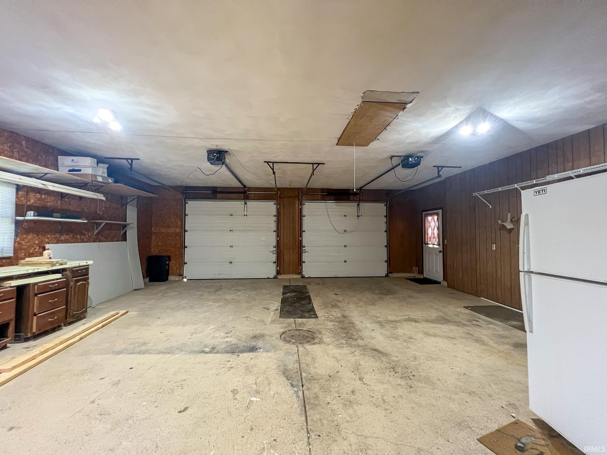 Garage with freestanding refrigerator and a garage door opener