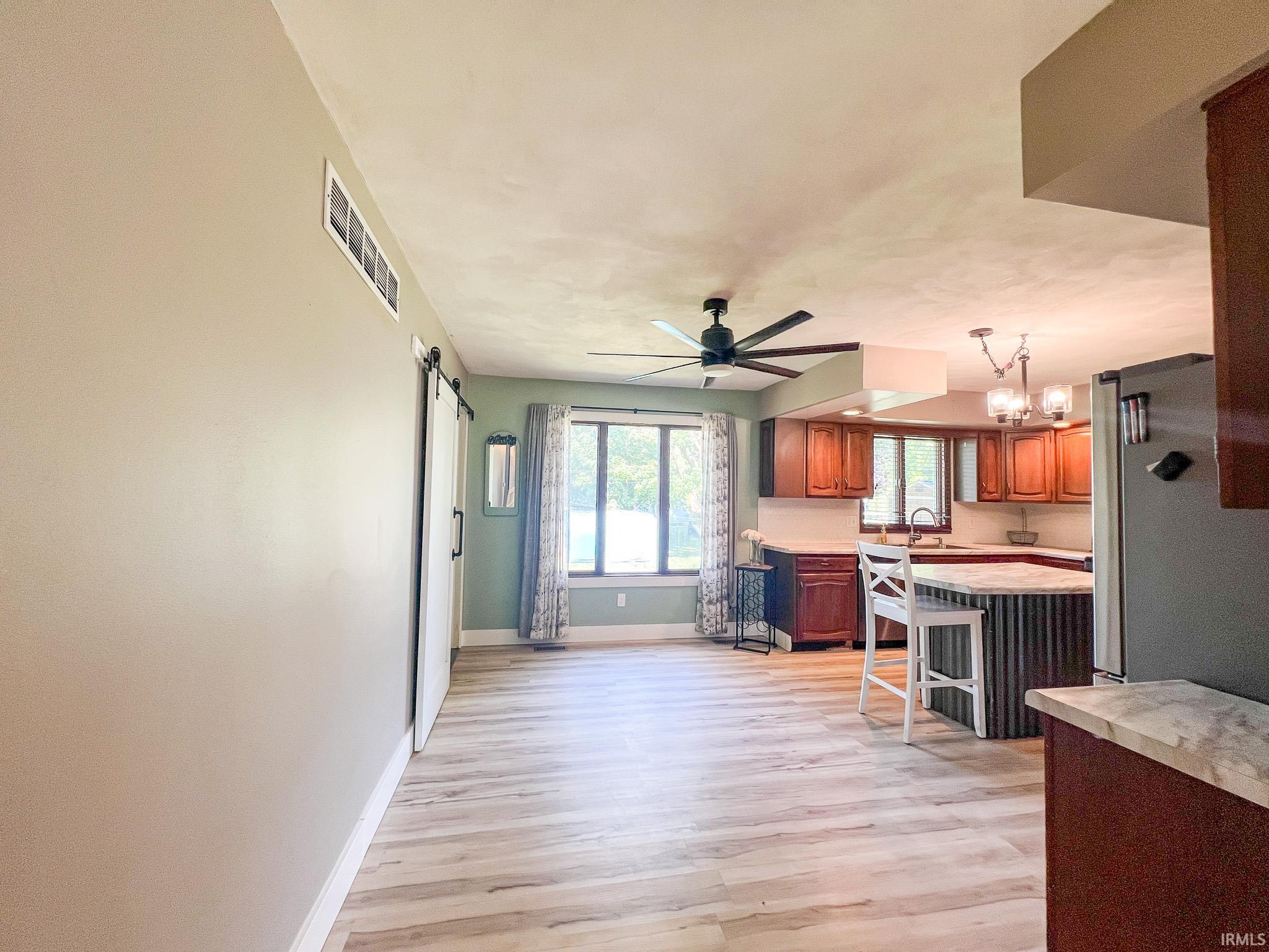 Dining area featuring a barn door, and light wood-style floors