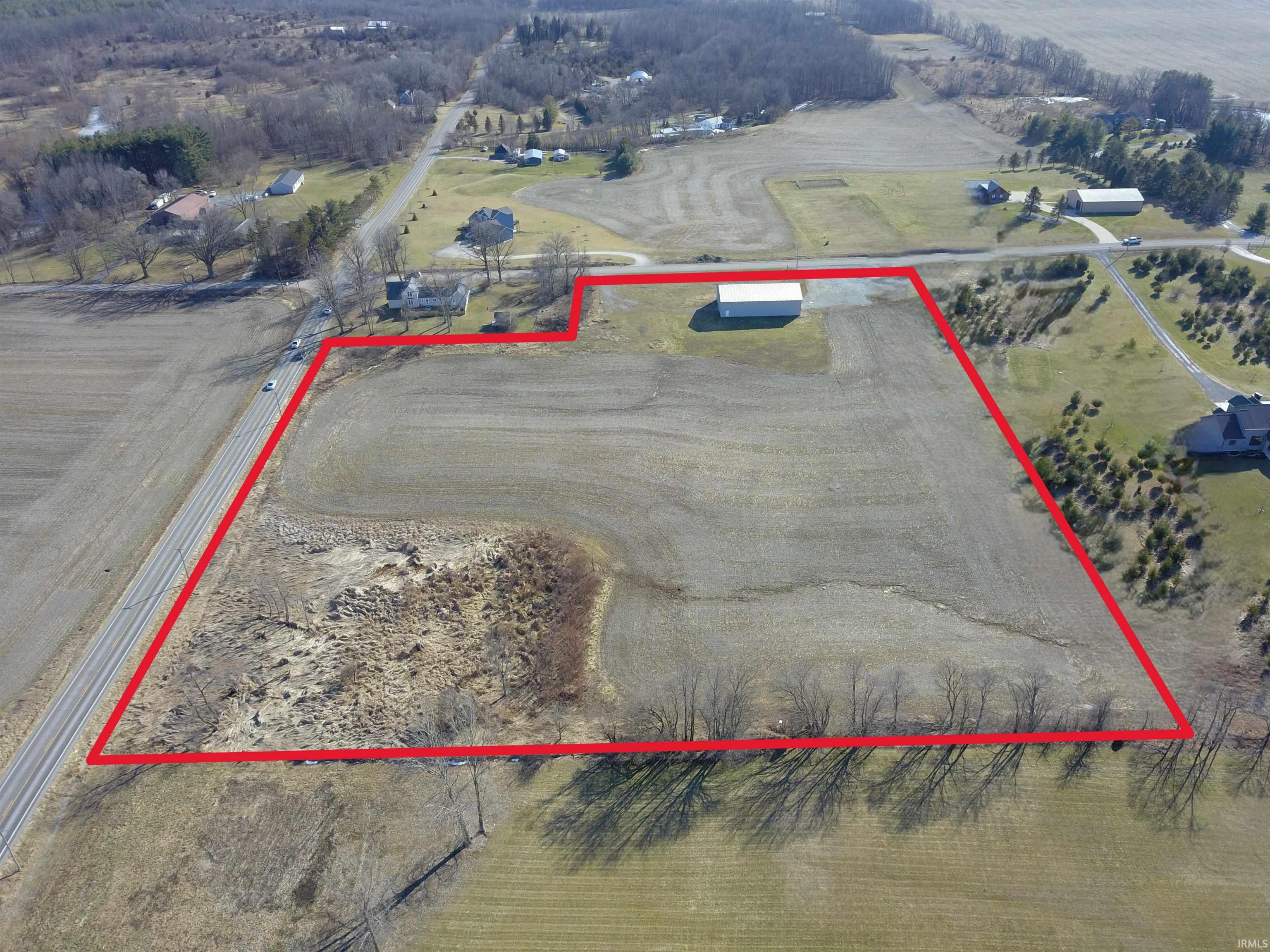 Aerial view of sparsely populated area with property parcel outlined