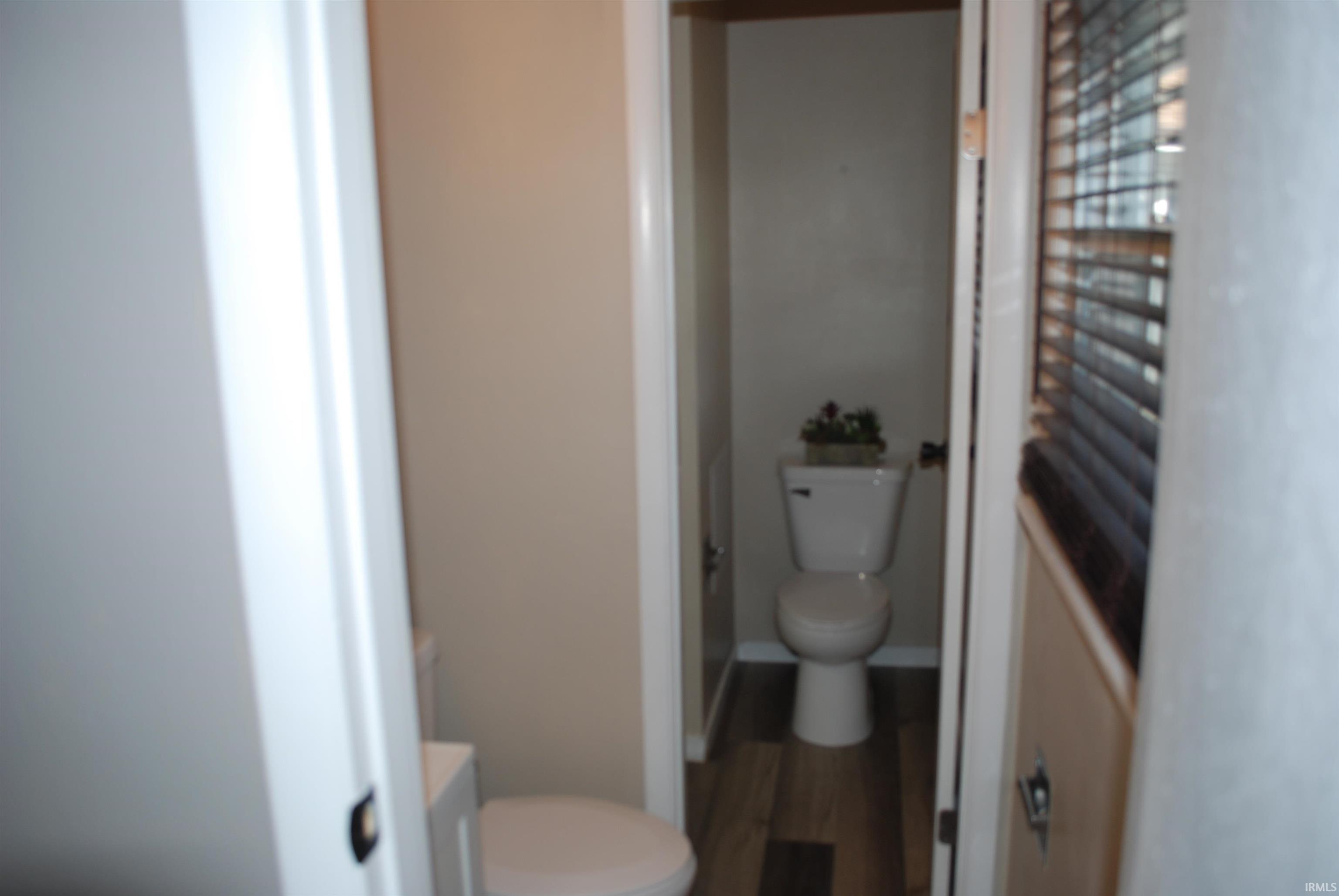 Bathroom with toilet and wood finished floors