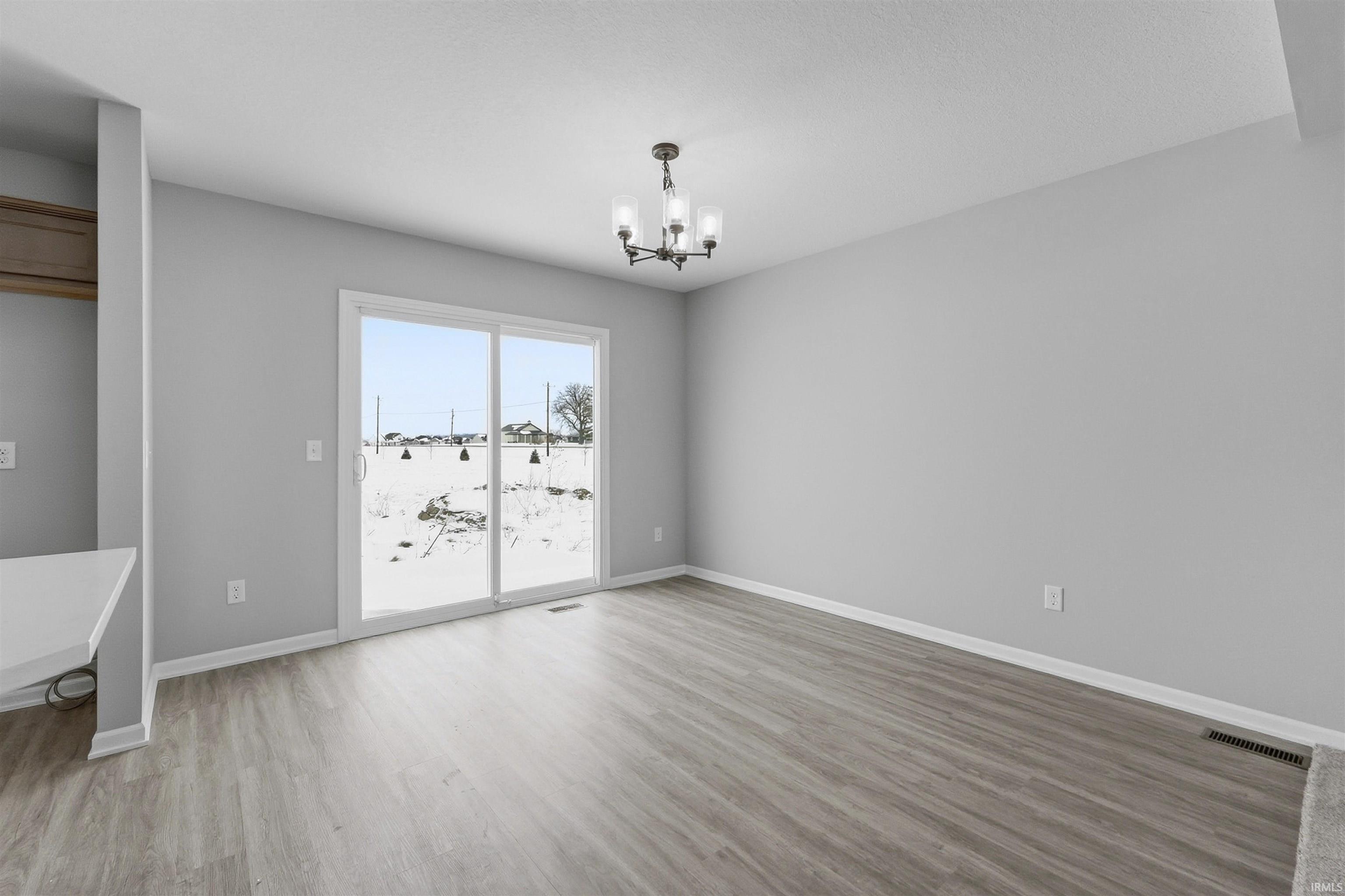Unfurnished dining area with a chandelier and light wood-style flooring