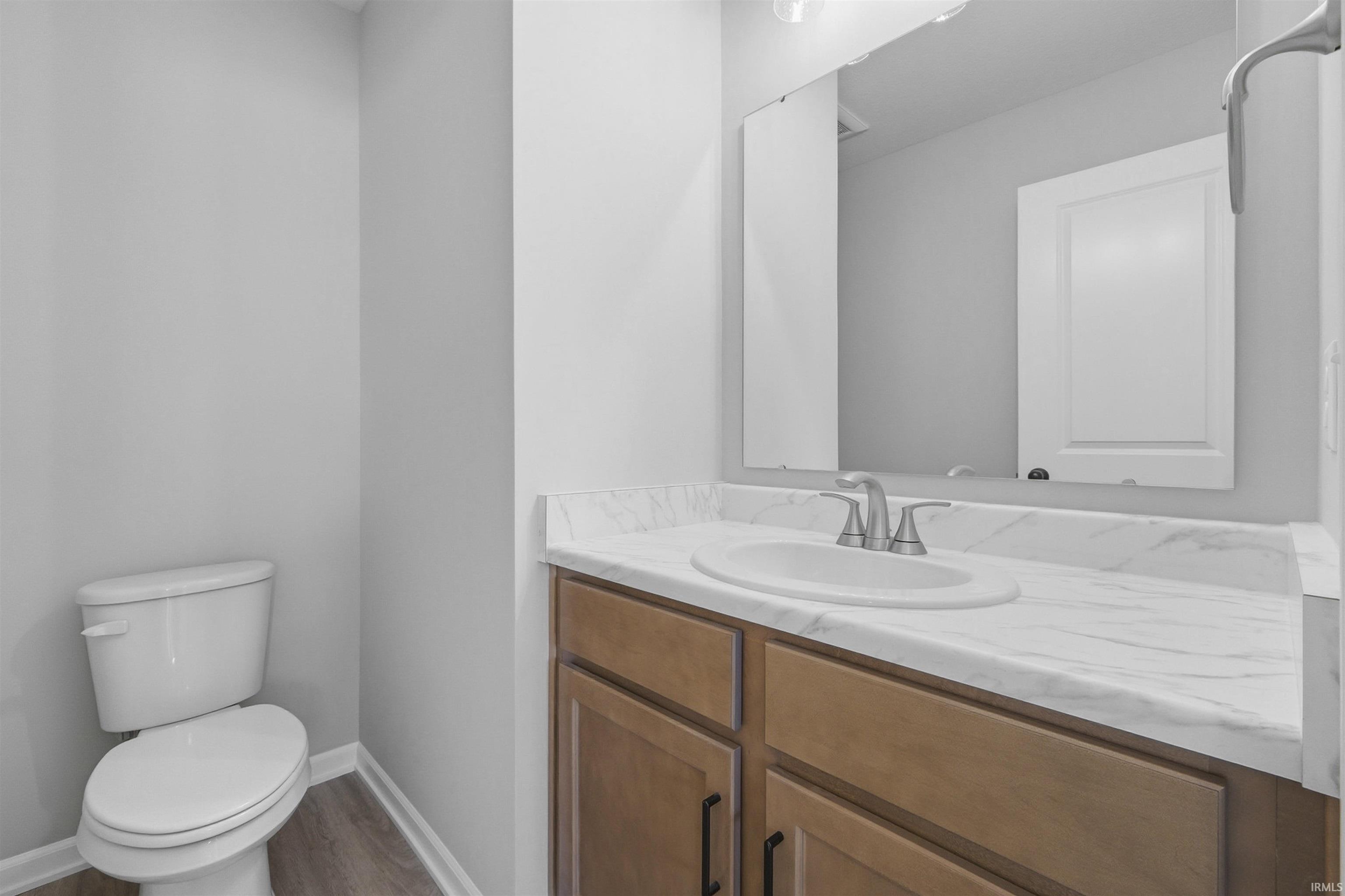 Half bathroom featuring vanity and light wood finished floors