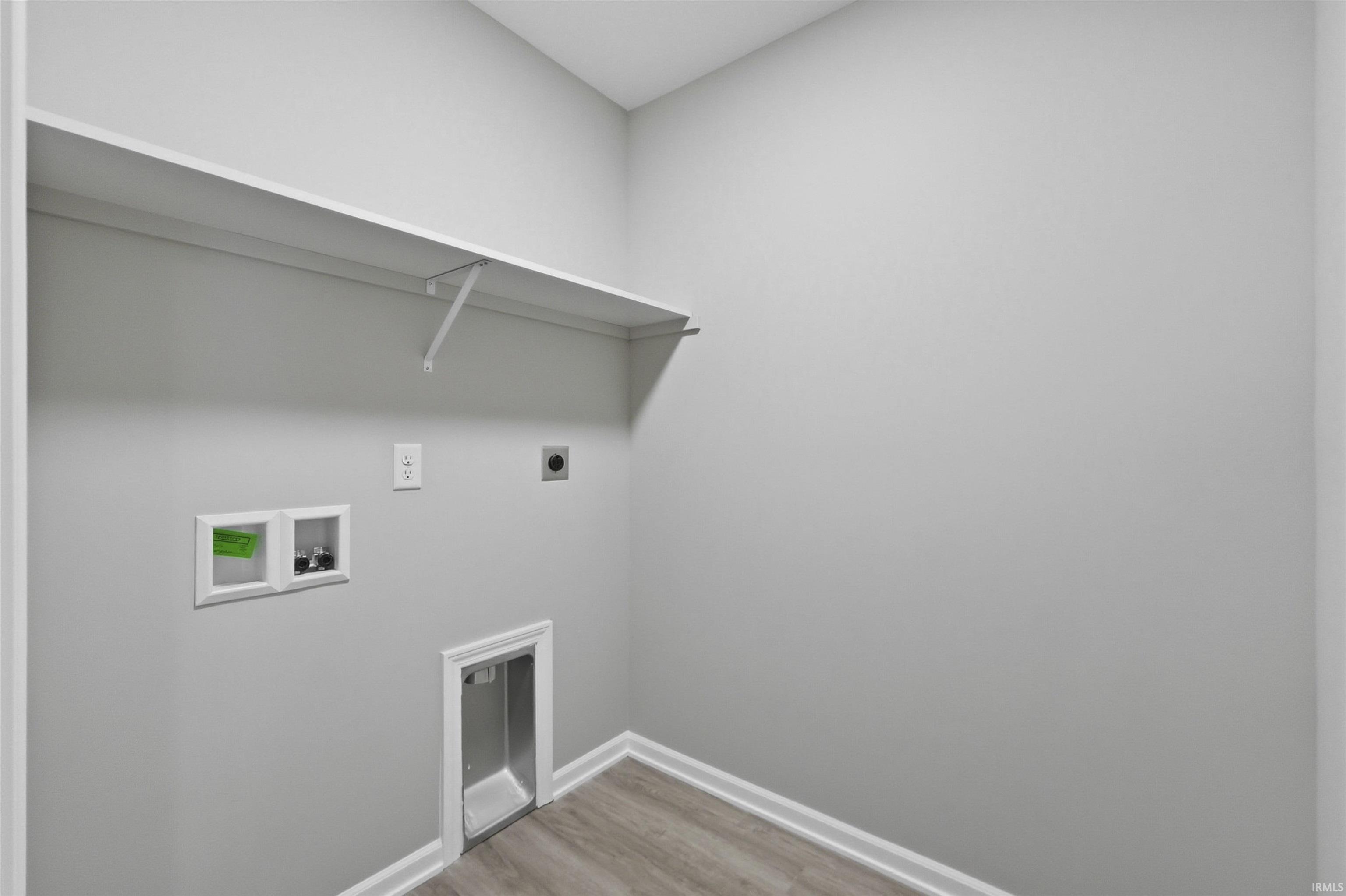 Laundry area with light wood finished floors, hookup for an electric dryer, and hookup for a washing machine