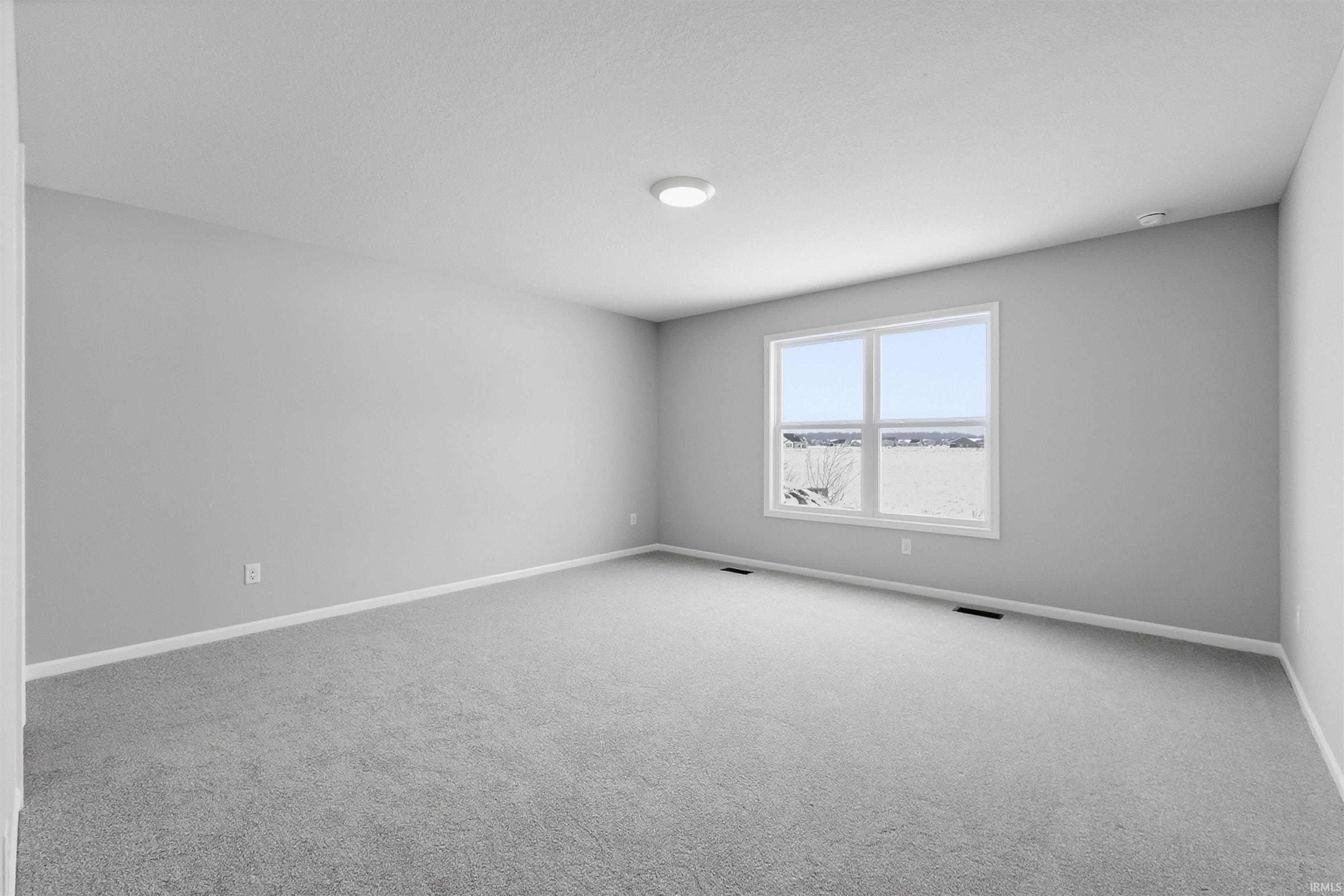 Carpeted spare room with baseboards