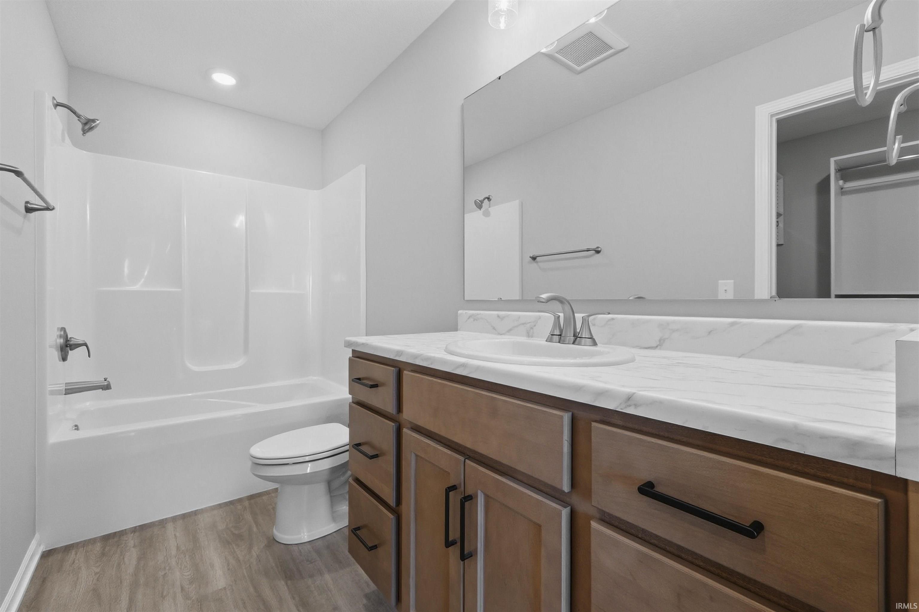 Full bathroom with vanity, light wood finished floors, and shower / bath combination