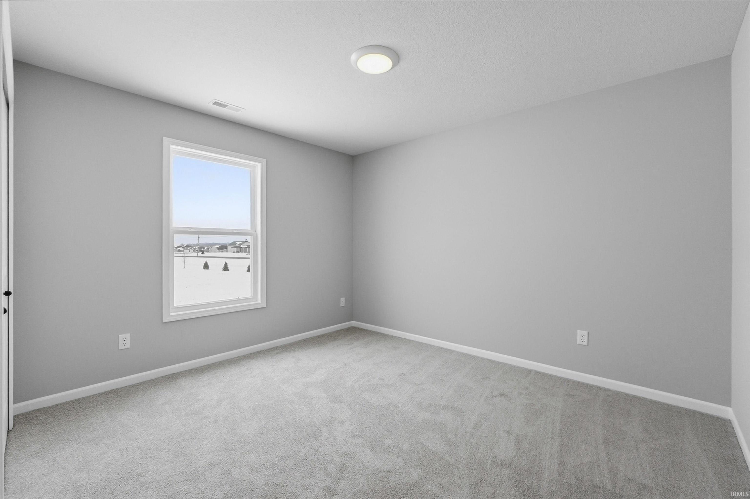 Unfurnished room with baseboards and light carpet